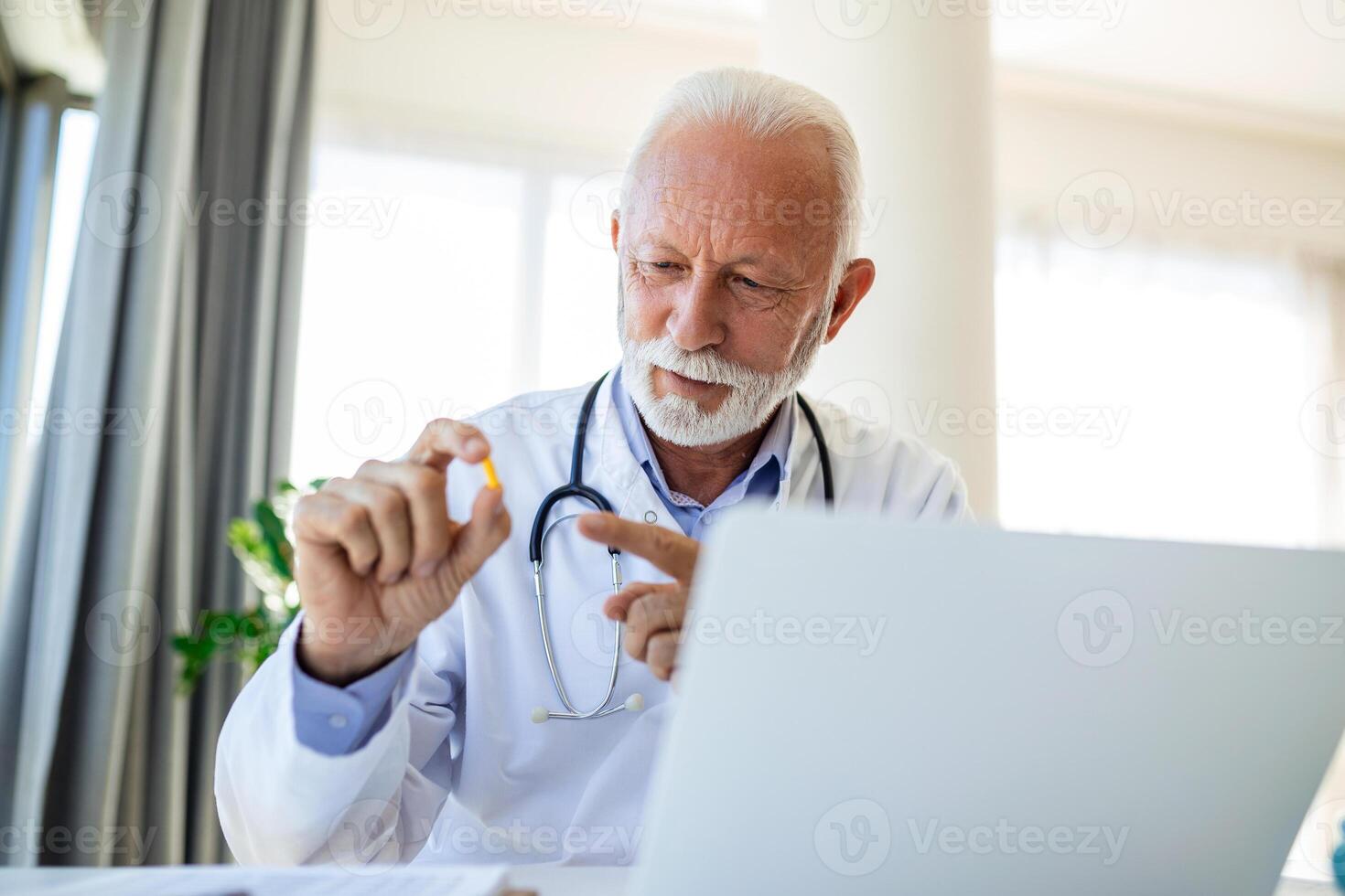 Doctor online. Senior medic talking to client on laptop computer from his office. Mature male therapist explaining medical treatment to patient through a video call with laptop in the consultation. photo