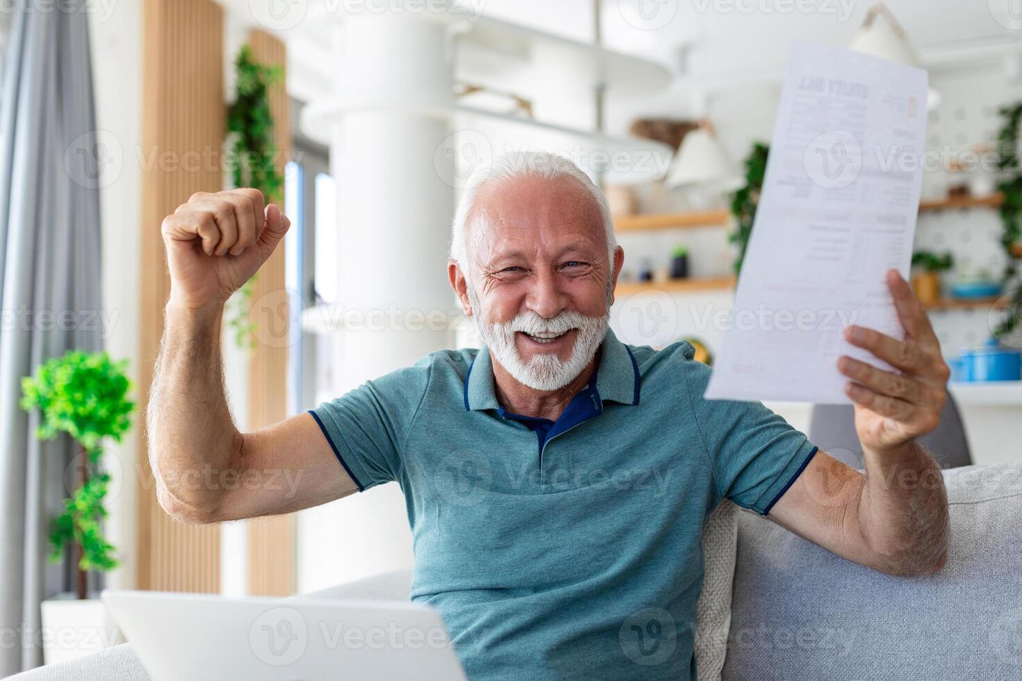 Surprised laughing happy old mature retired man looking through paper document, feeling excited analyzing financial information, getting taxes refund or bank loan approval at home. photo