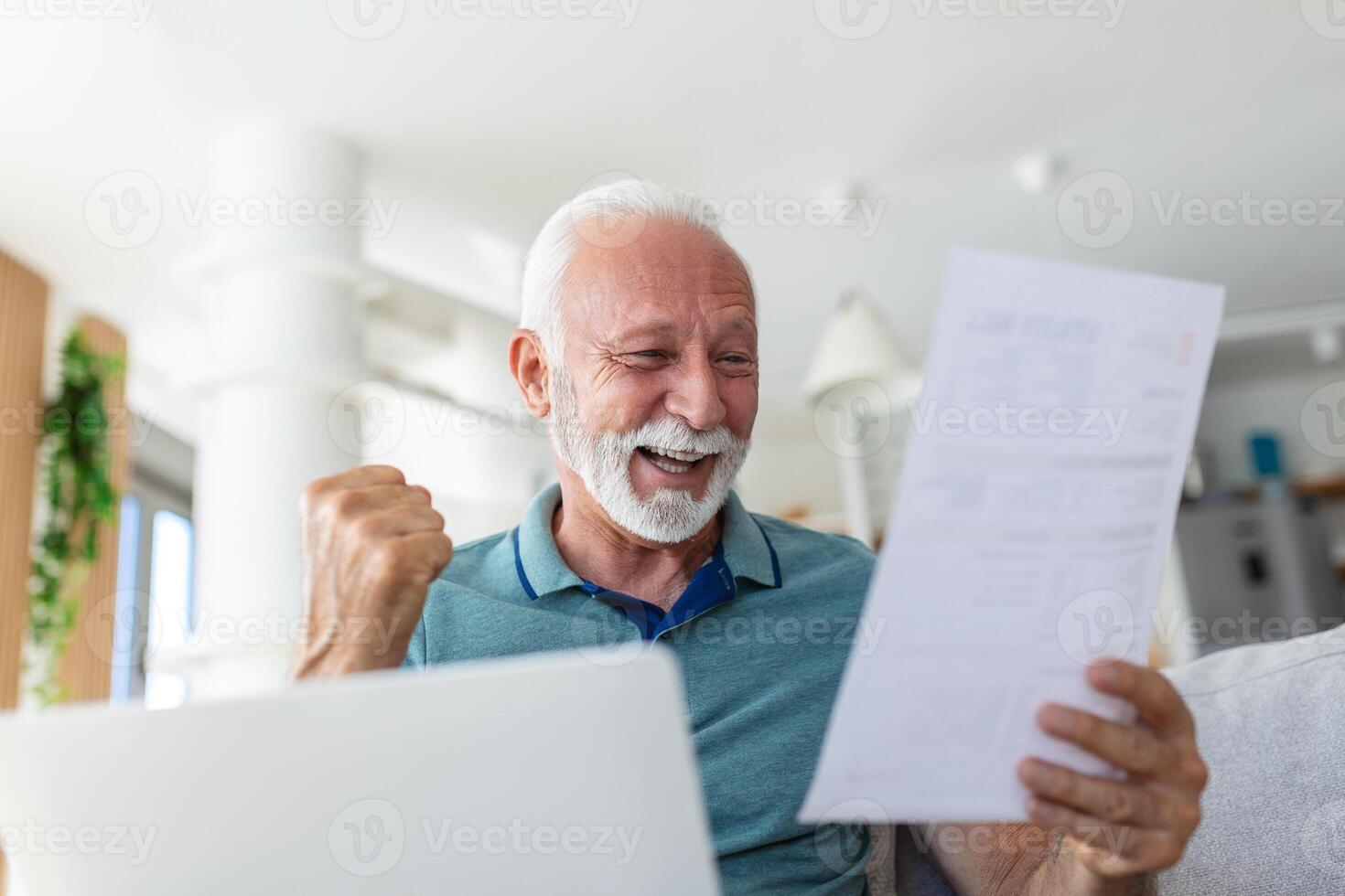 Surprised laughing happy old mature retired man looking through paper document, feeling excited analyzing financial information, getting taxes refund or bank loan approval at home. photo