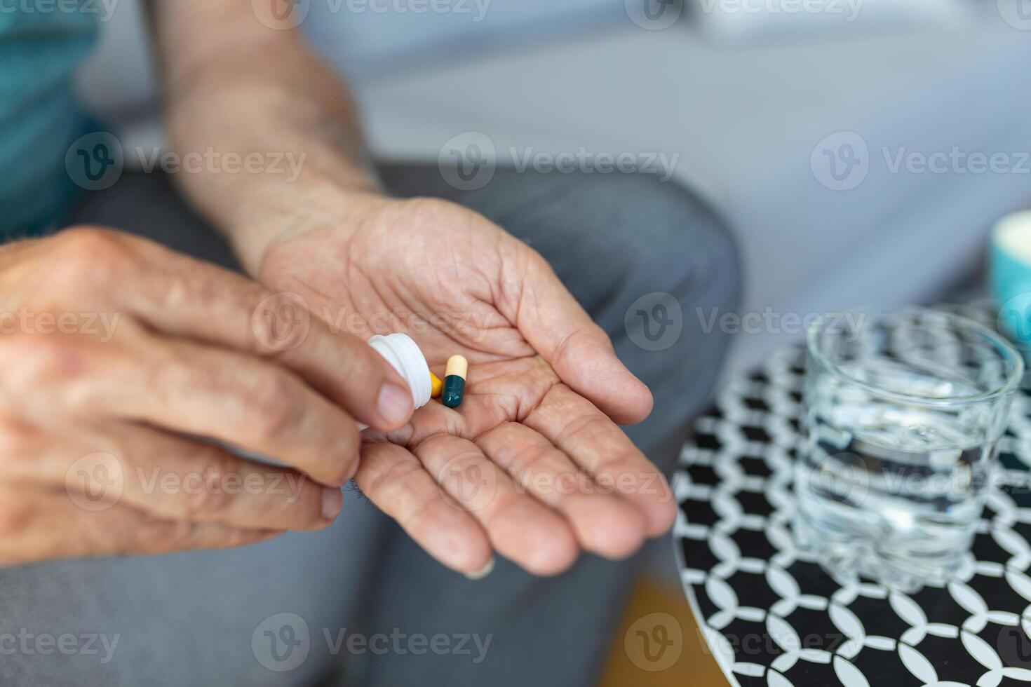 Senior man takes pill with glass of water in hand. Stressed mature man drinking sedated antidepressant meds. Man feels depressed, taking drugs. Medicines at work photo