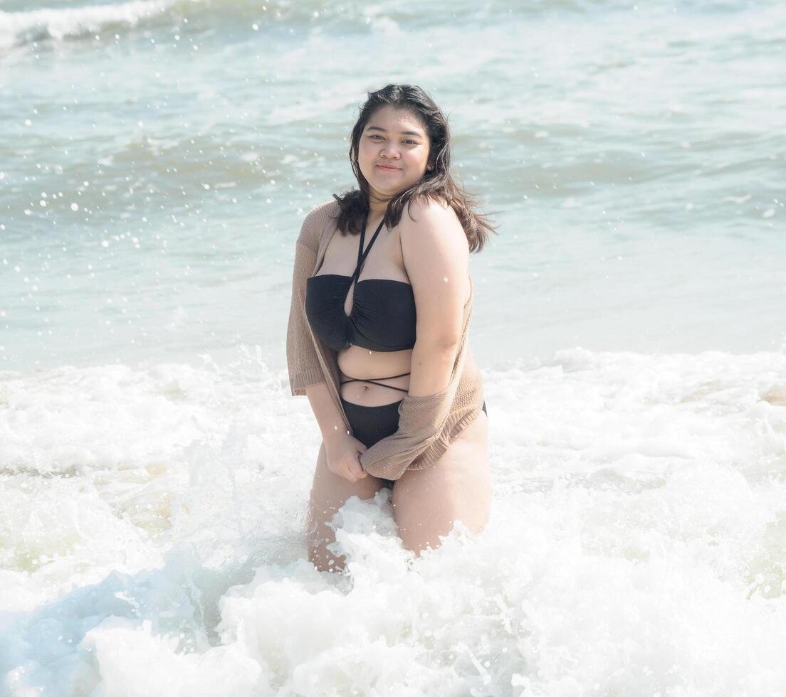 Portrait young asian woman fat chubby cute beautiful smile happy fun enjoy relax bikini swimwear body sexy front view sea beach white sand clean bluesky calm nature ocean wave water travel on holiday photo