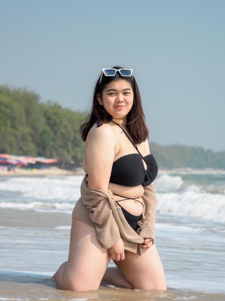 retrato joven asiático mujer grasa gordito linda hermosa sonrisa contento divertido disfrutar relajarse bikini trajes de baño cuerpo sexy frente ver mar playa blanco arena limpiar cielo azul calma naturaleza Oceano ola agua viaje en fiesta foto