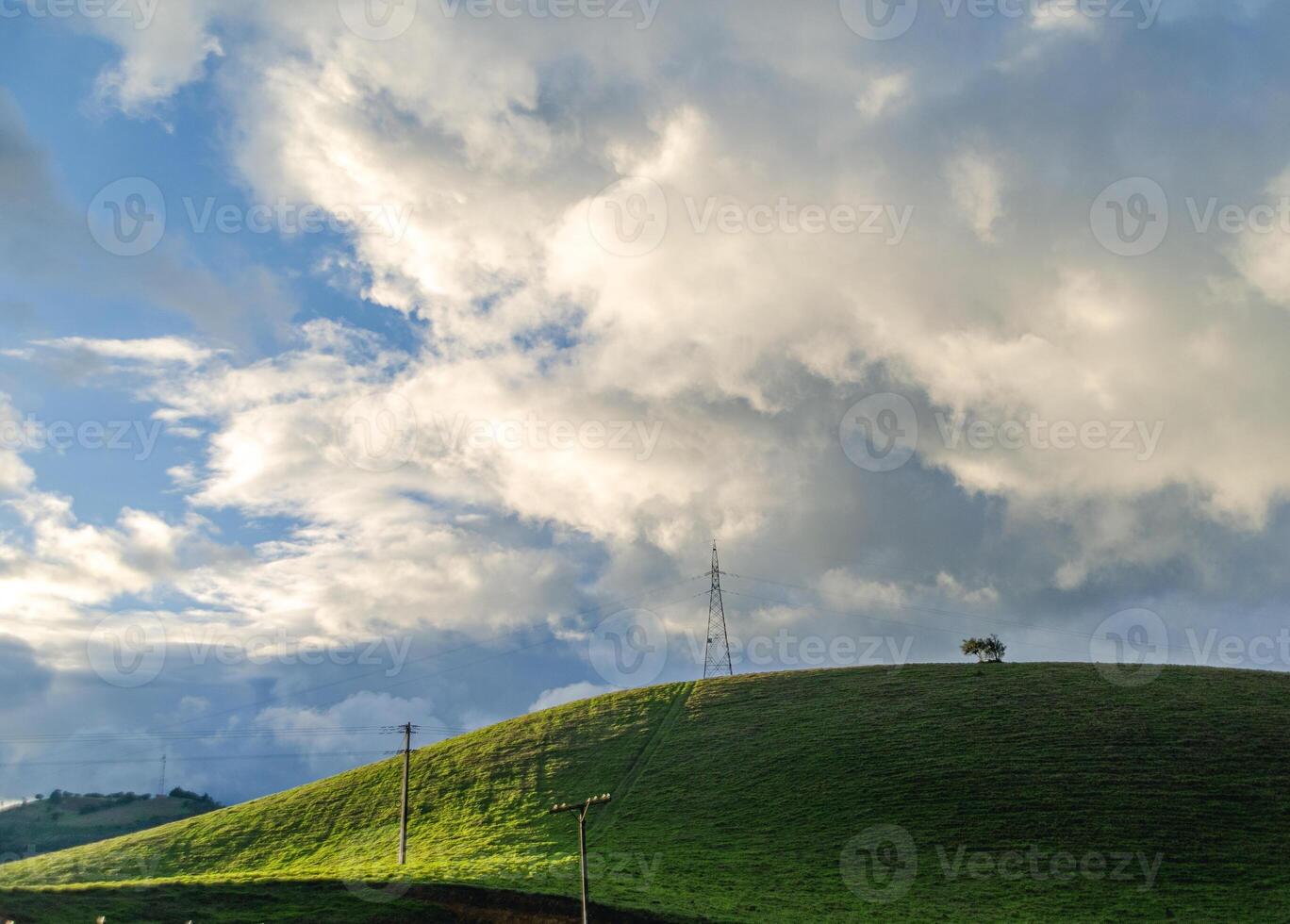 landscape photo of green hills at sunset in a dramatic and cloudy sky