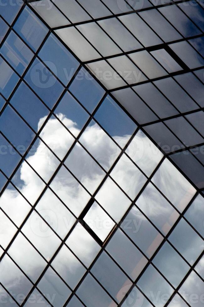 potrait shot of tilted glass structure reflecting dramatic ninbus clouds photo