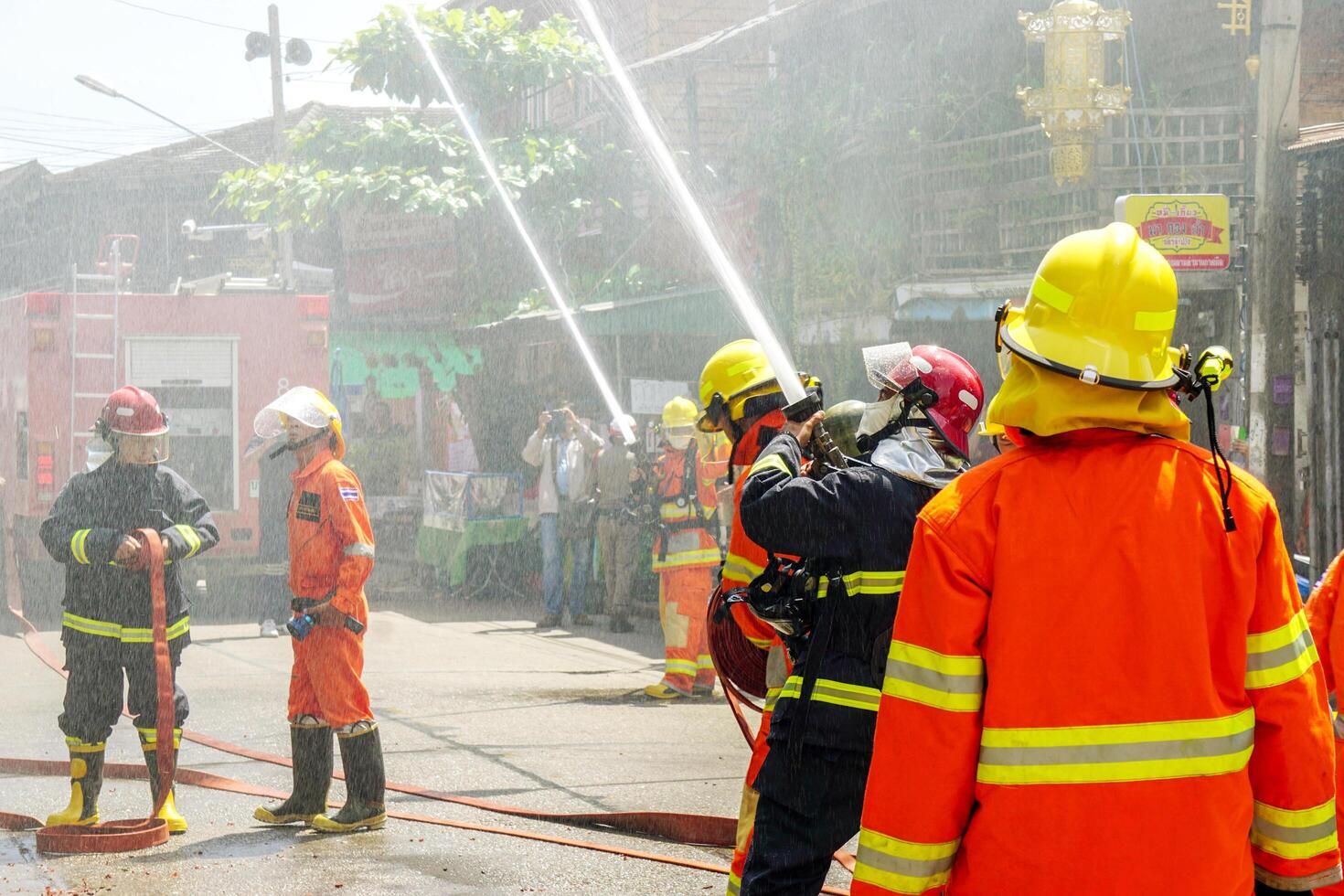 Lampang, Thailand, 2018 - Firefighters group of Lampang city confederate water spray and control the hoses to quench the fire in the real annual rehearsal fire drill in urban city. photo