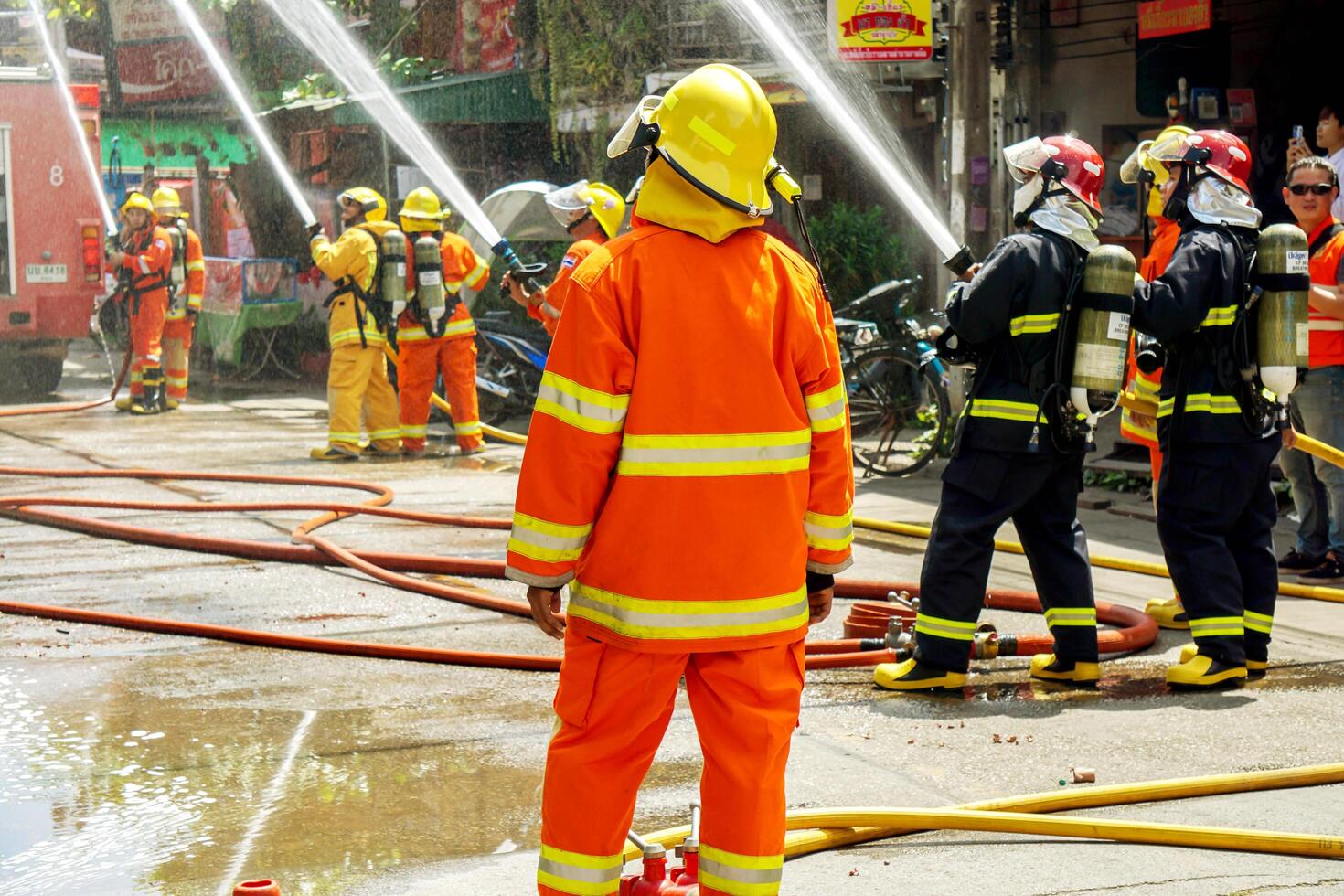 Lampang, Thailand, 2018 -  Firefighters group of Lampang city confederate water spray and control the hoses to quench the fire in the real annual rehearsal fire drill in urban city. photo