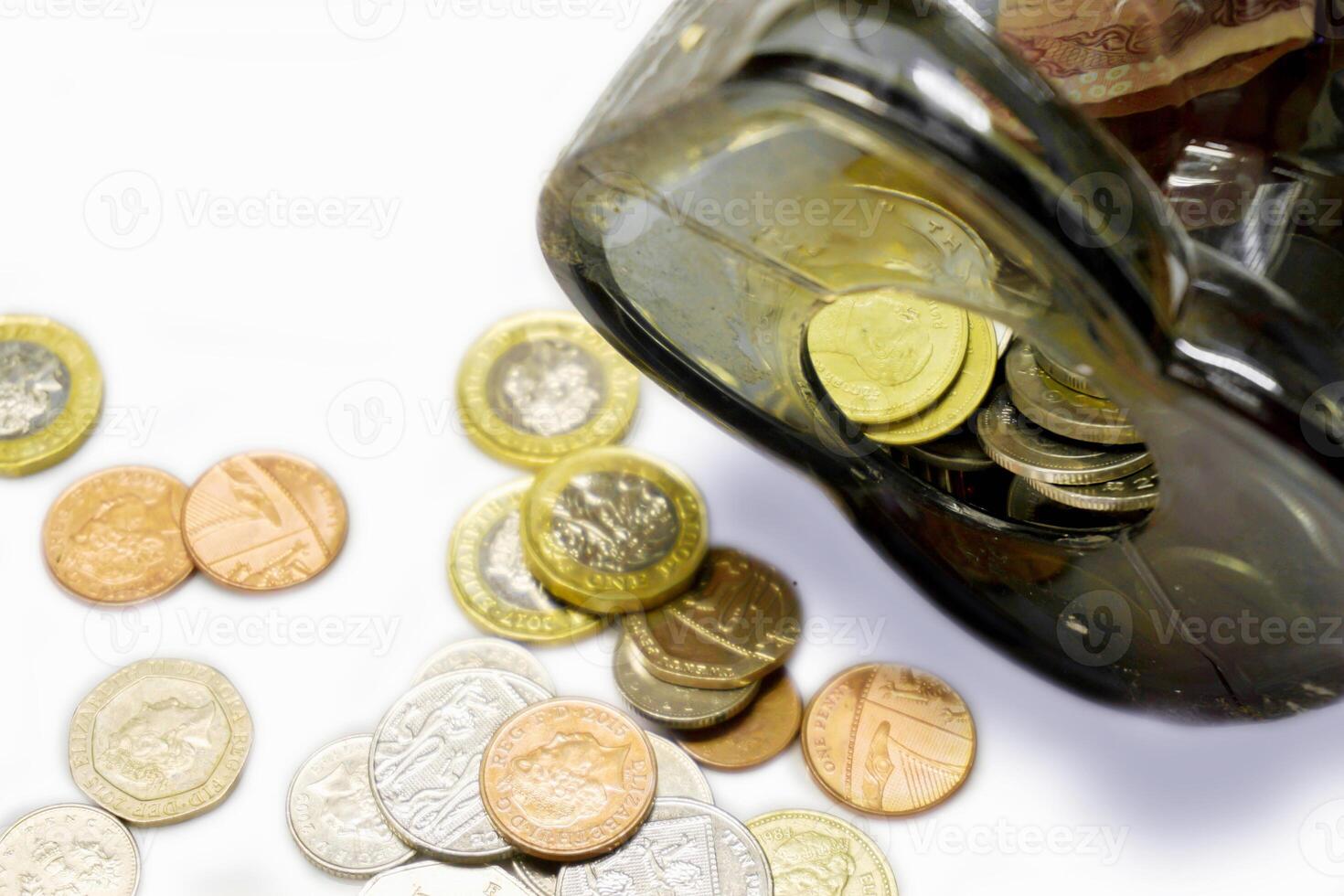 Top view and crop of British currency coins open from the piggy bank laid out scattered and crop on white background. photo