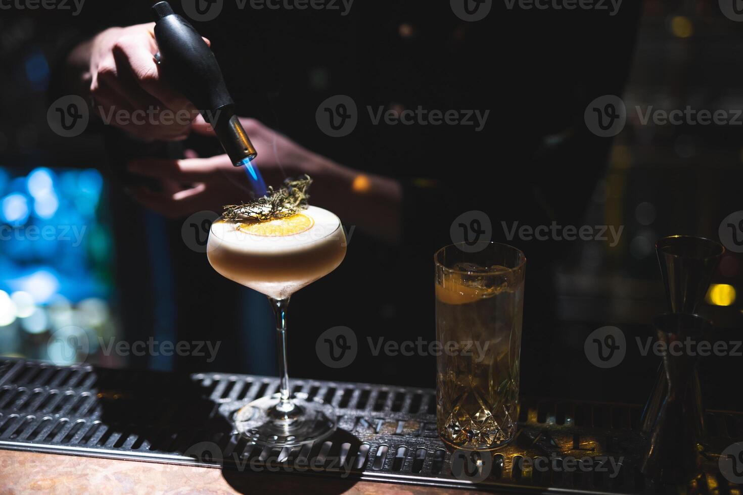 the bartender prepares a beautiful alcoholic cocktail at the bar counter photo