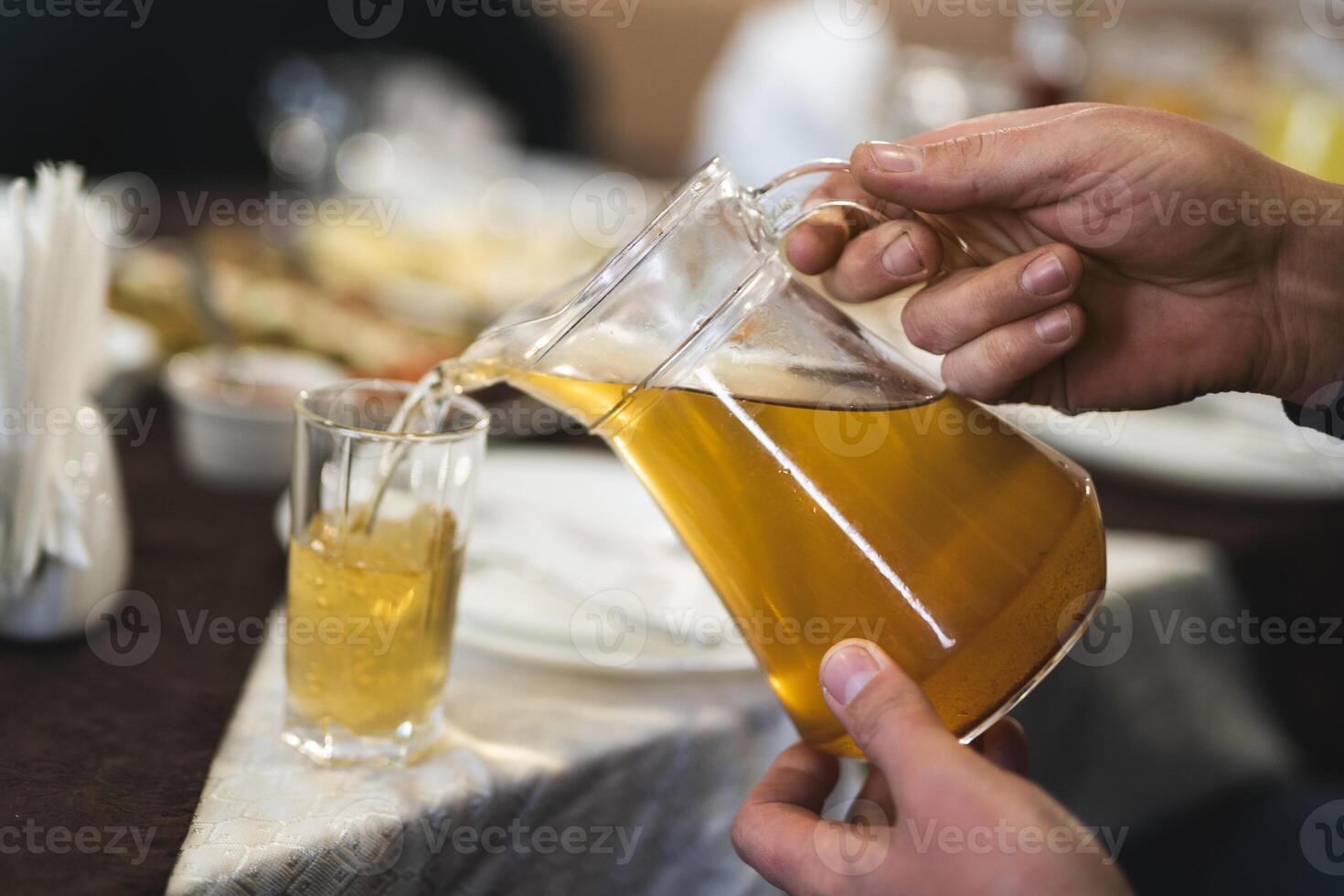 pouring a fresh drink from a decanter into a glass photo