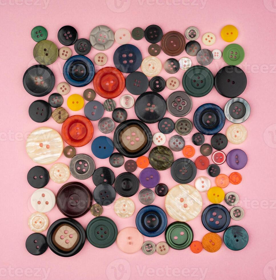 Many different buttons on a pink background photo