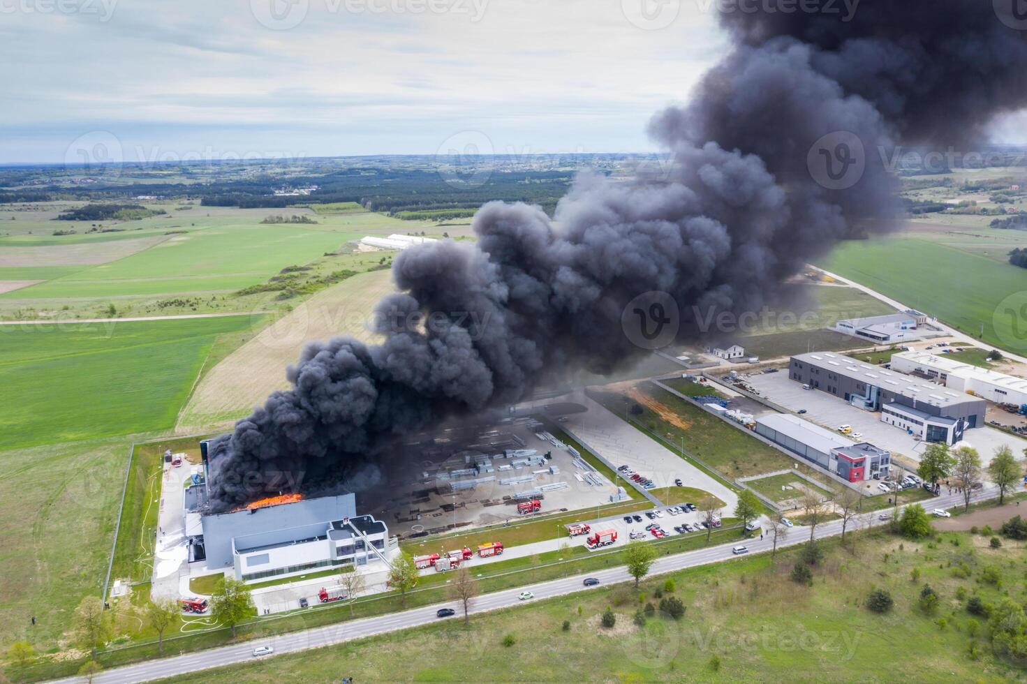 Aerial view of burnt industrial warehouse or logistics center building after big fire with huge smoke from burned roof photo