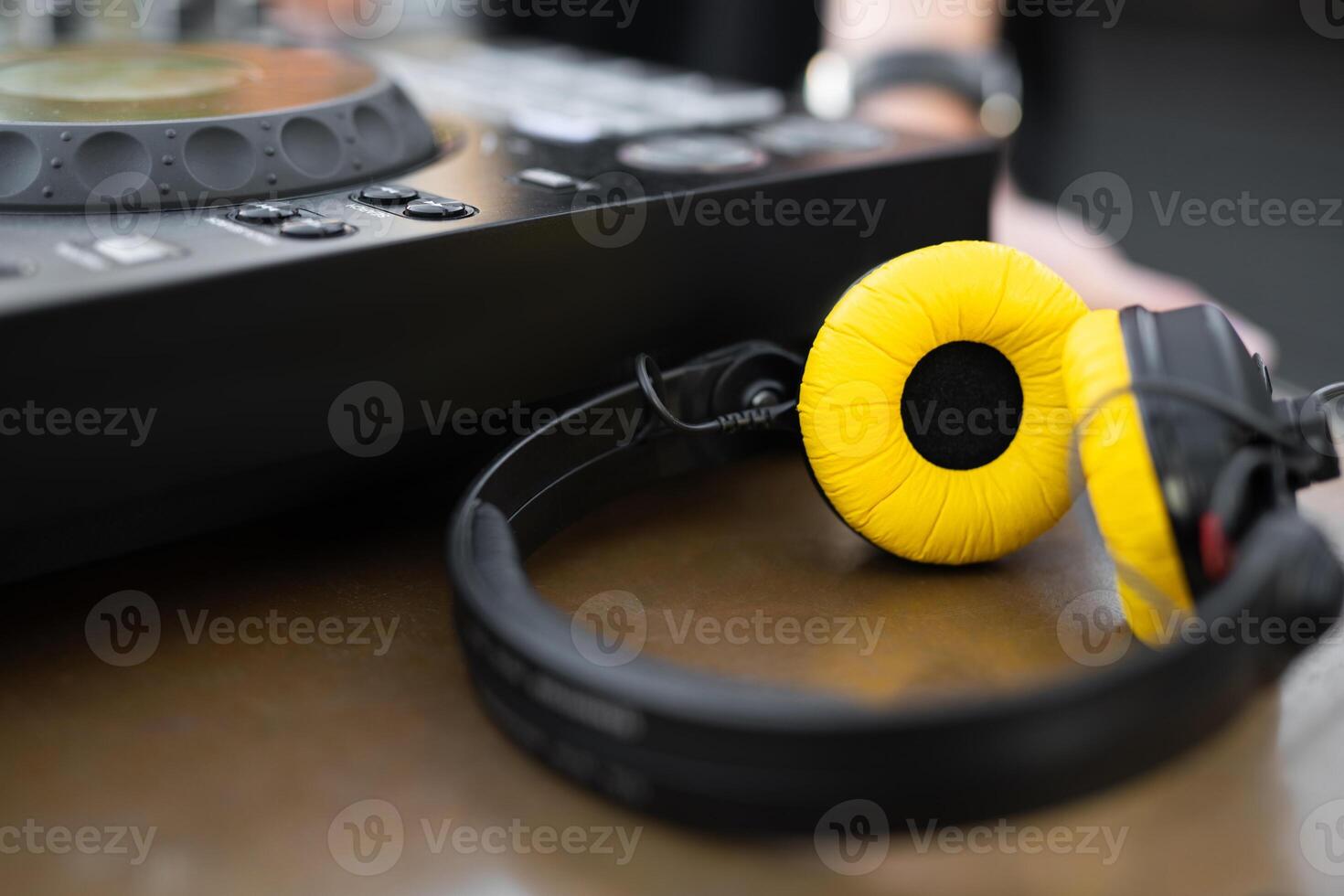 stylish yellow DJ headphones near the controller on the table photo