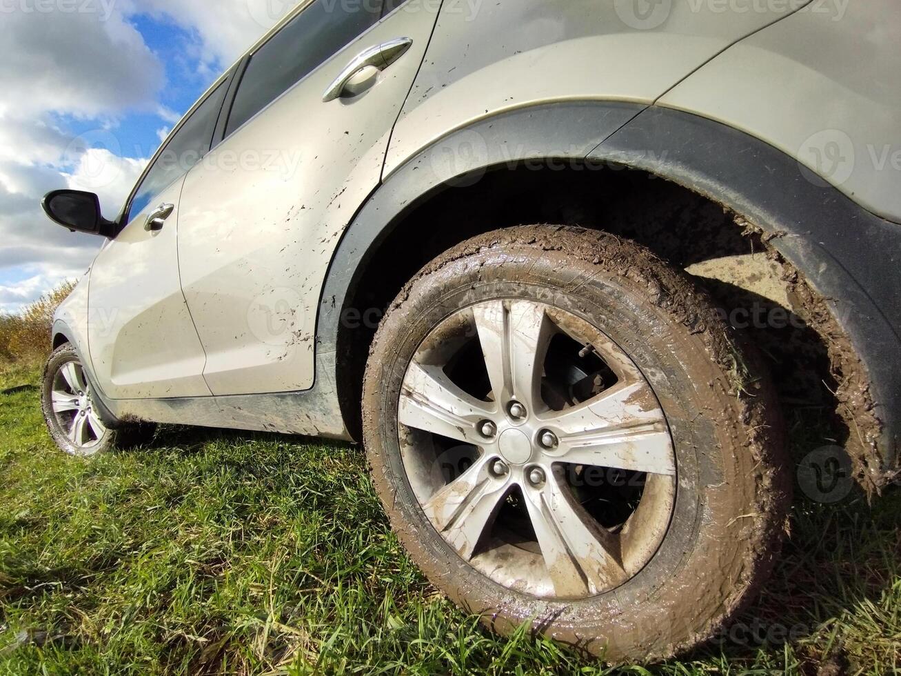 close-up of dirty wheels of an off-road car in the mud photo