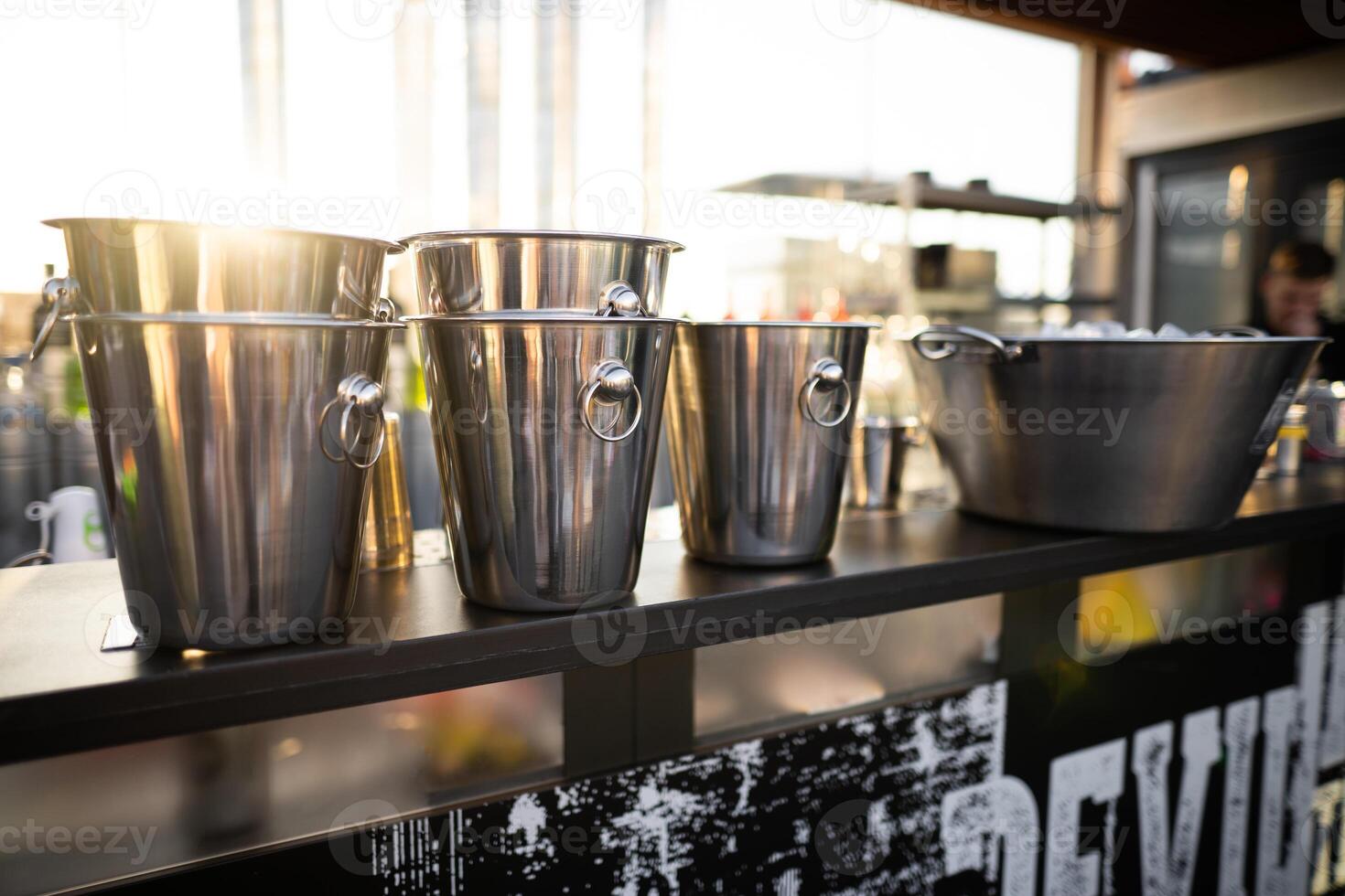 metal ice bucket on bar counter in sunlight photo