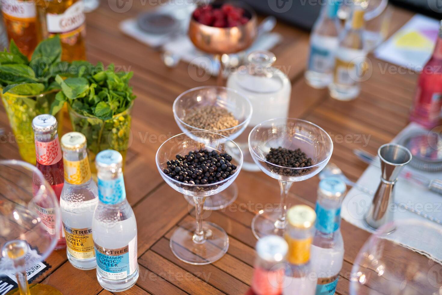 many different ingredients on the bartender's table for making alcoholic cocktails photo