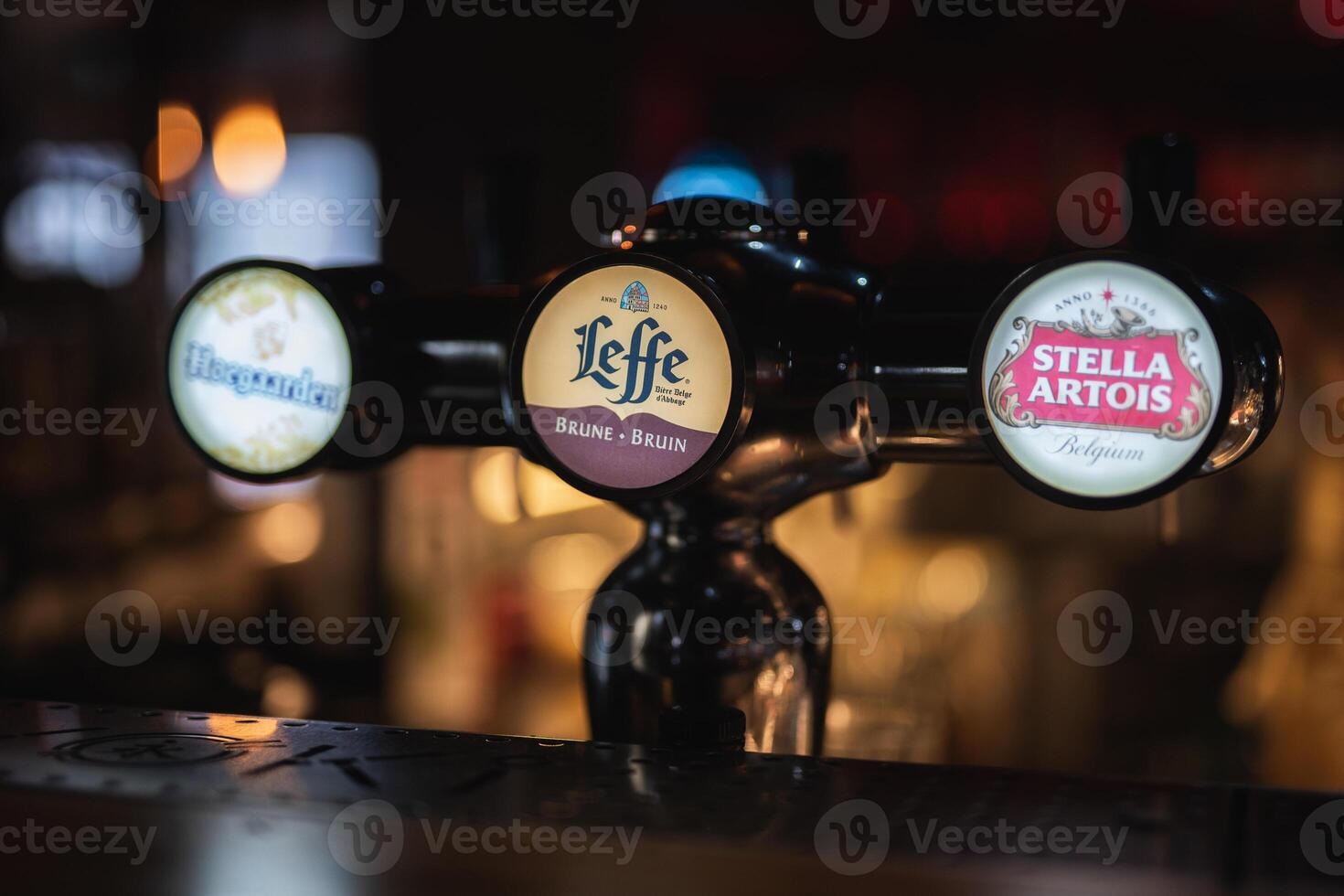 a tap with different brands of beer on the bar photo