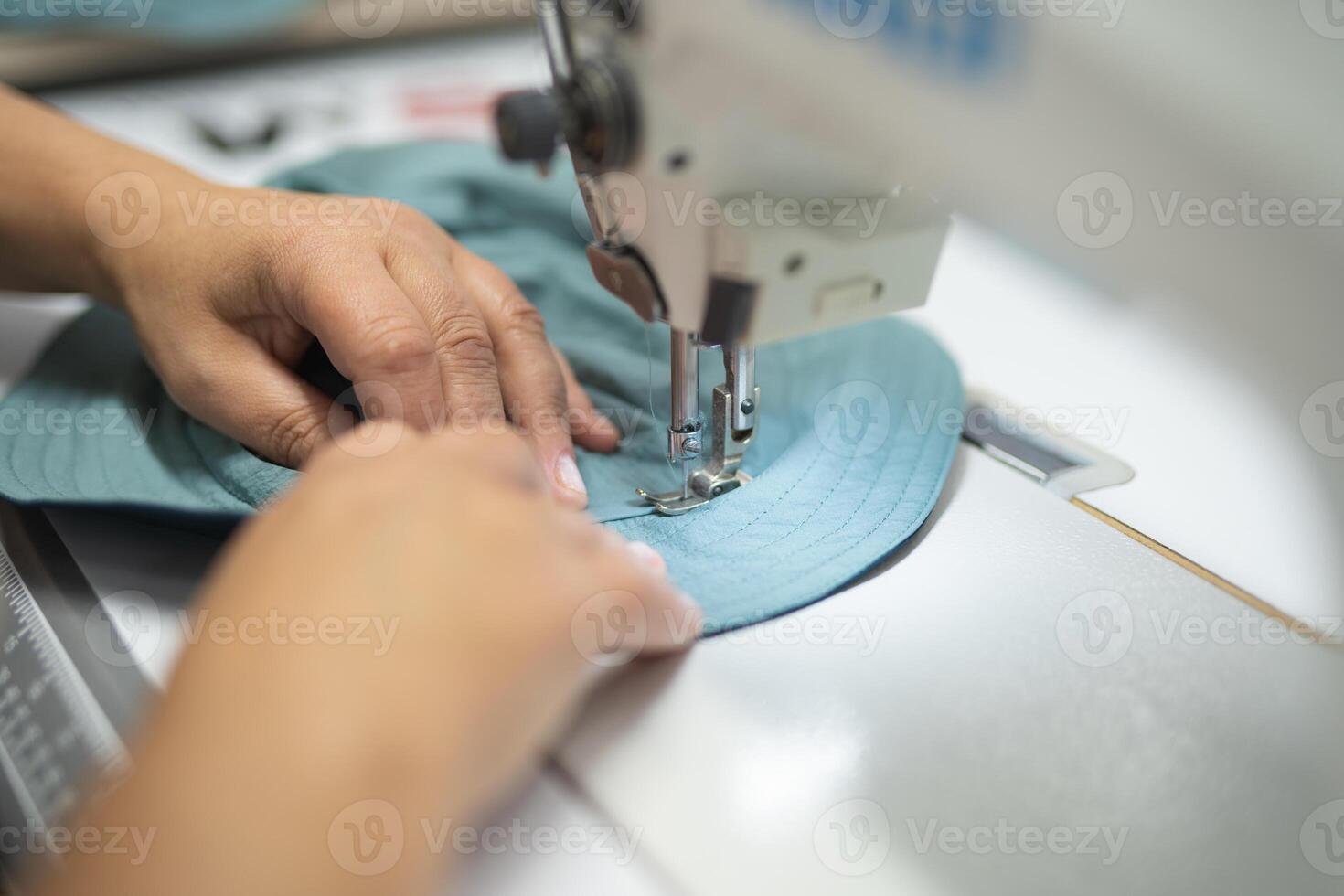 workers in an industrial garment factory sew clothes on sewing machine photo