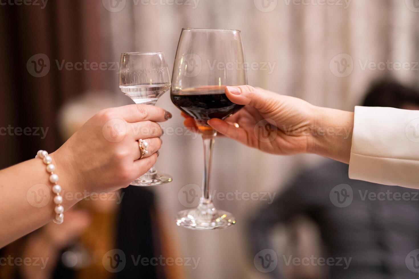 tintinamente lentes con alcohólico bebidas en su manos foto