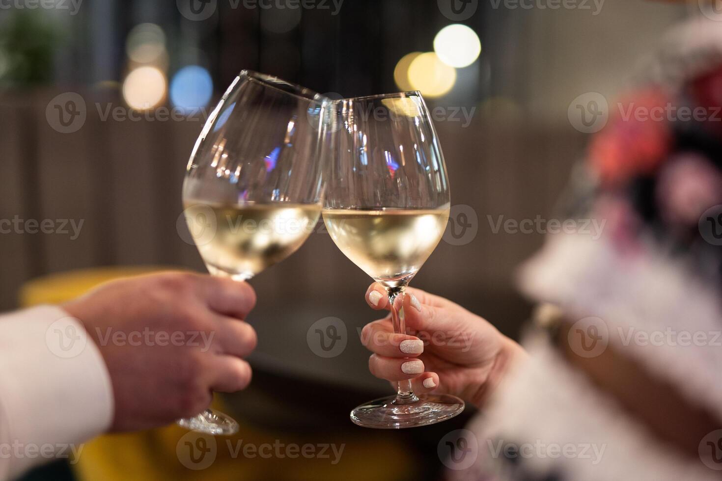 two people are holding glasses with an alcoholic drink photo