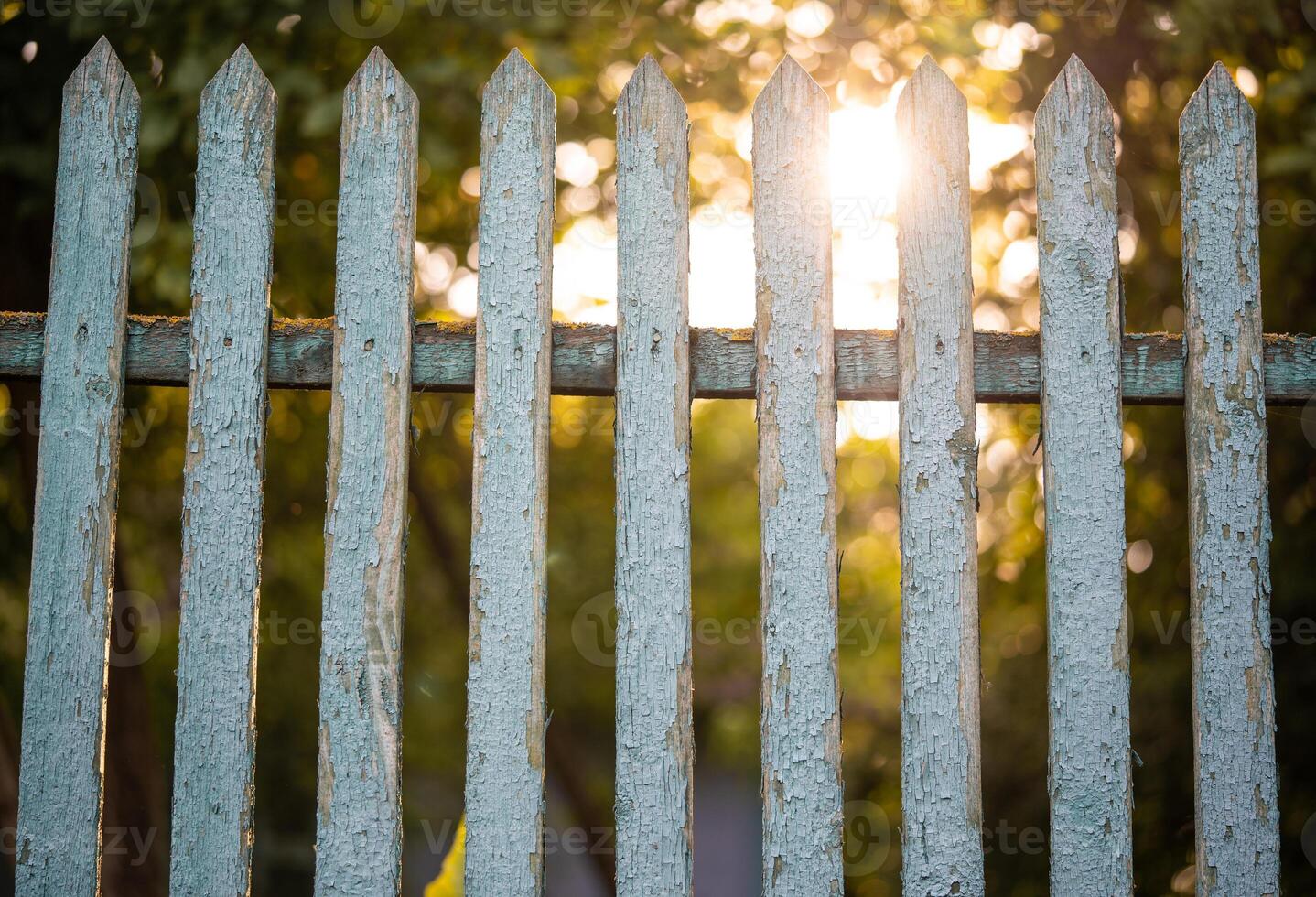 beautiful wooden fence in the village in the contrast sunlight photo