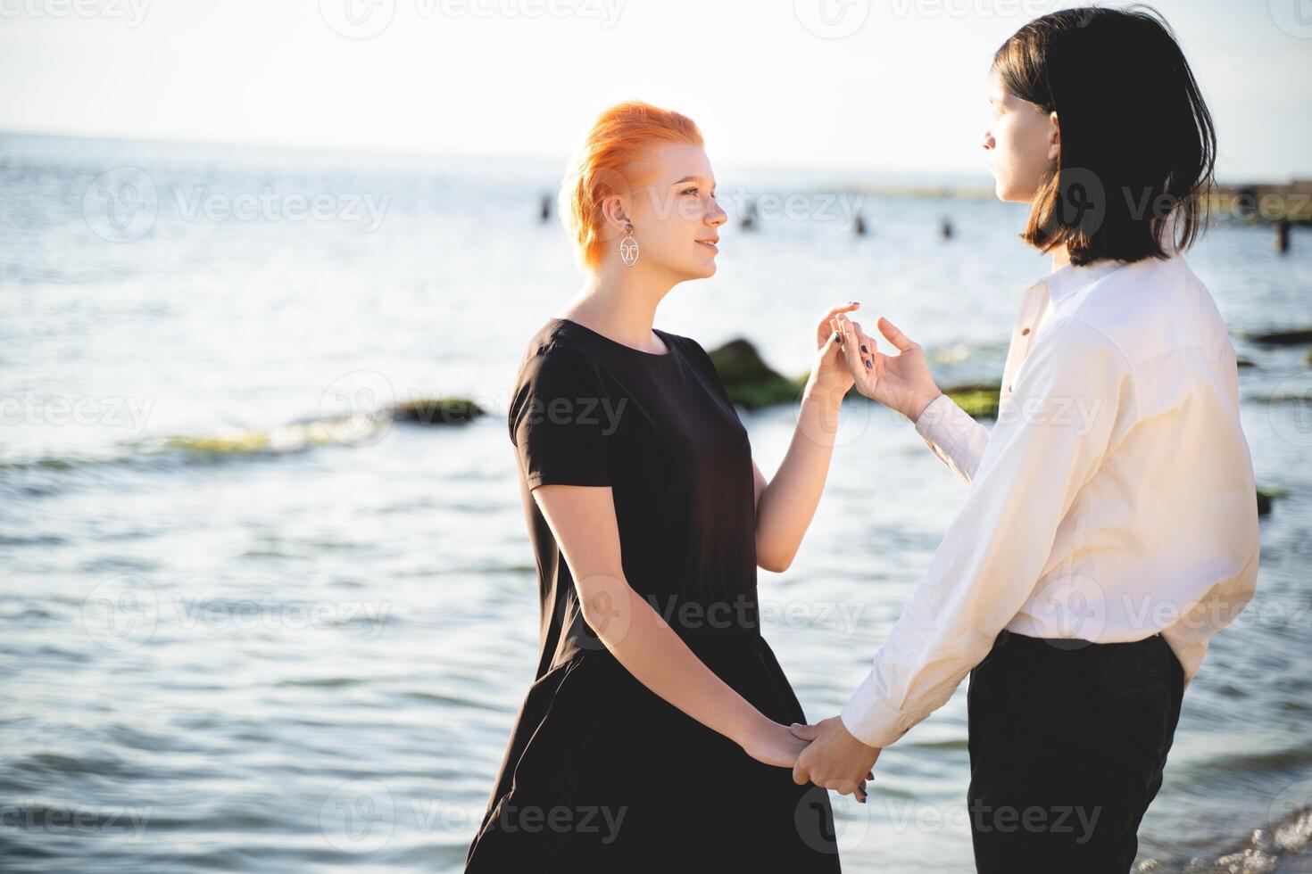 two lovers boy and girl are happy walking and hugging on the sandy beach near the sea. photo