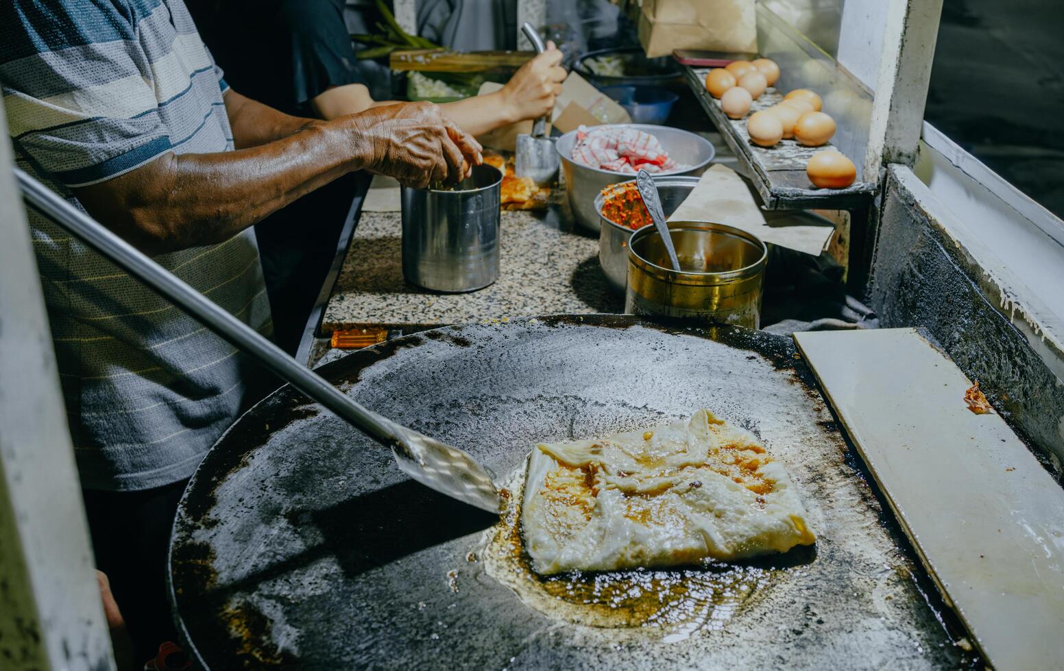 Making process of Martabak Telor. Savoury pan-fried pastry stuffed with egg, meat and spices. Martabak is popular take away food among Malaysian or Indonesian. photo