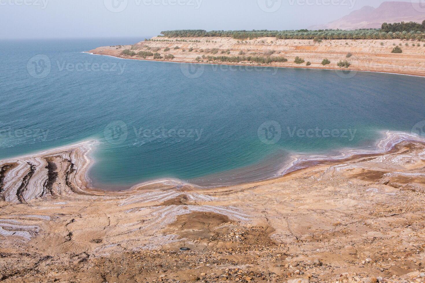 View of Dead Sea coastline at sunset time in Jordan. Salt crystals at sunset. Dead sea landscape with mineral structures. photo