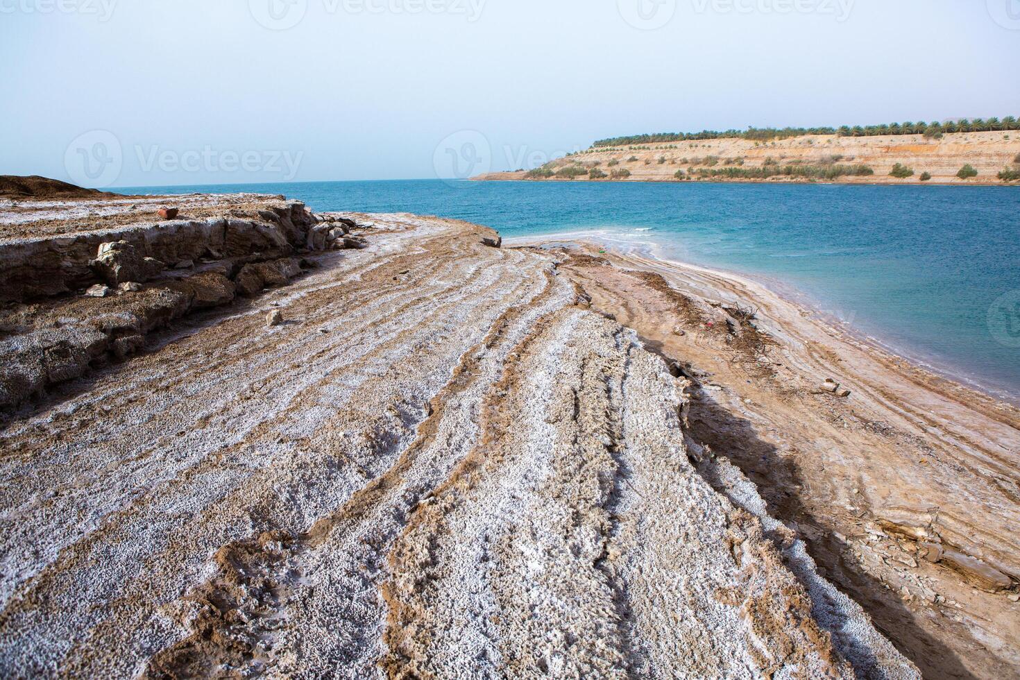 View of Dead Sea coastline at sunset time in Jordan. Salt crystals at sunset. Dead sea landscape with mineral structures. photo