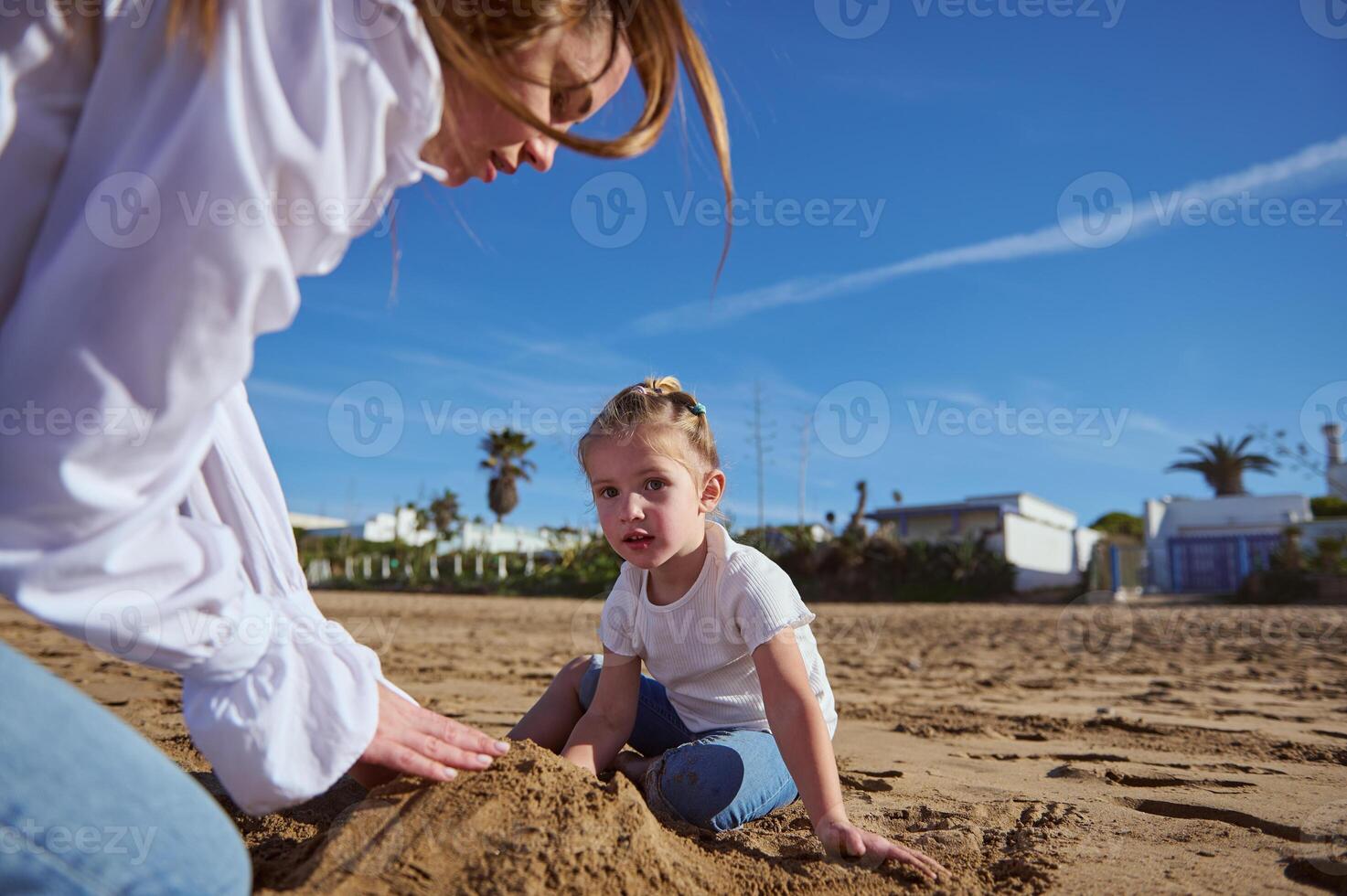 happy of mother and daughter building castle in sand at beach. Family lifestyle, Leisure activity, People. Vacations photo