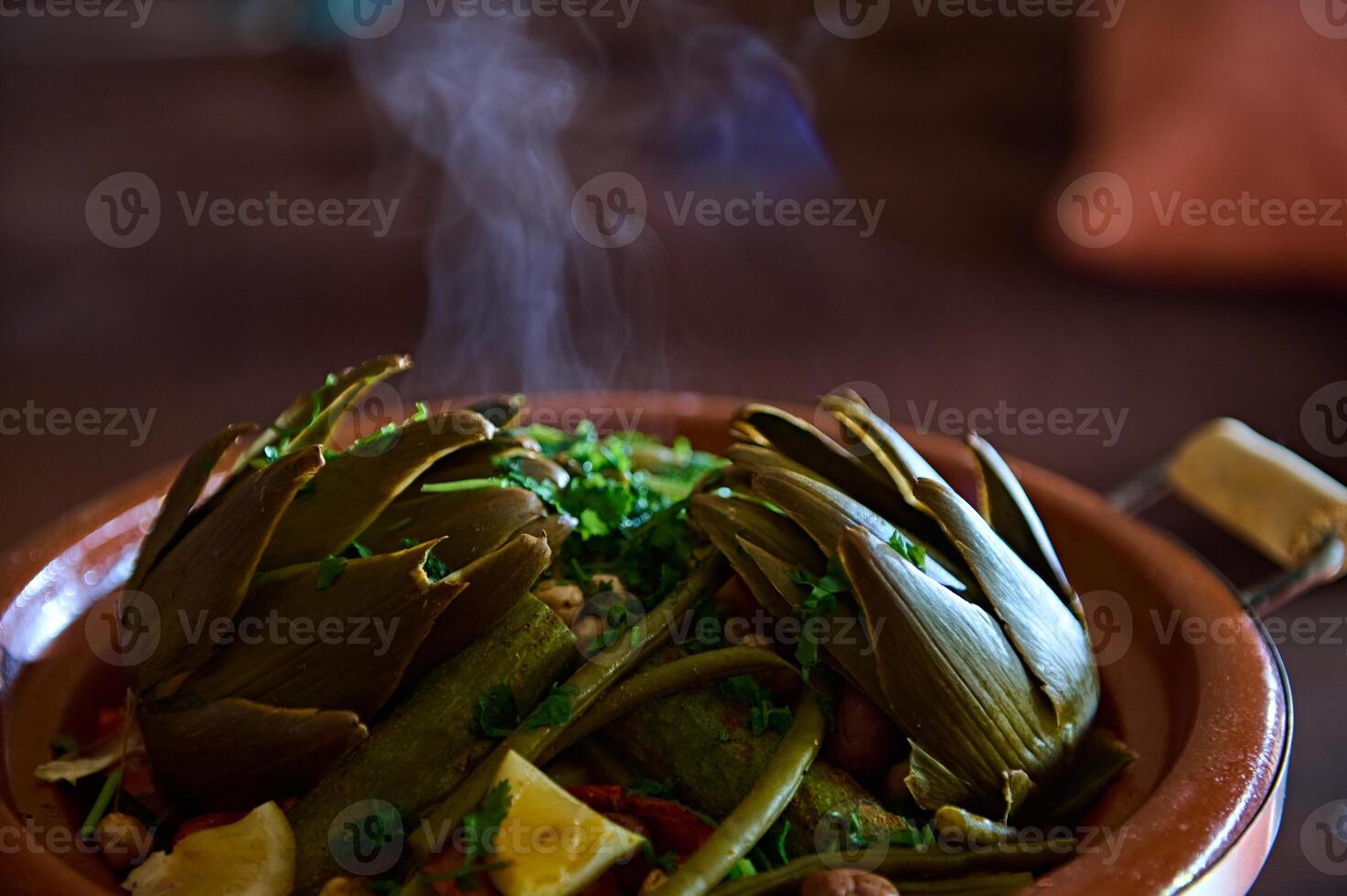 Close-up view of a hot vegetarian meal with organic veggies steamed in clay pot tagine with steam photo