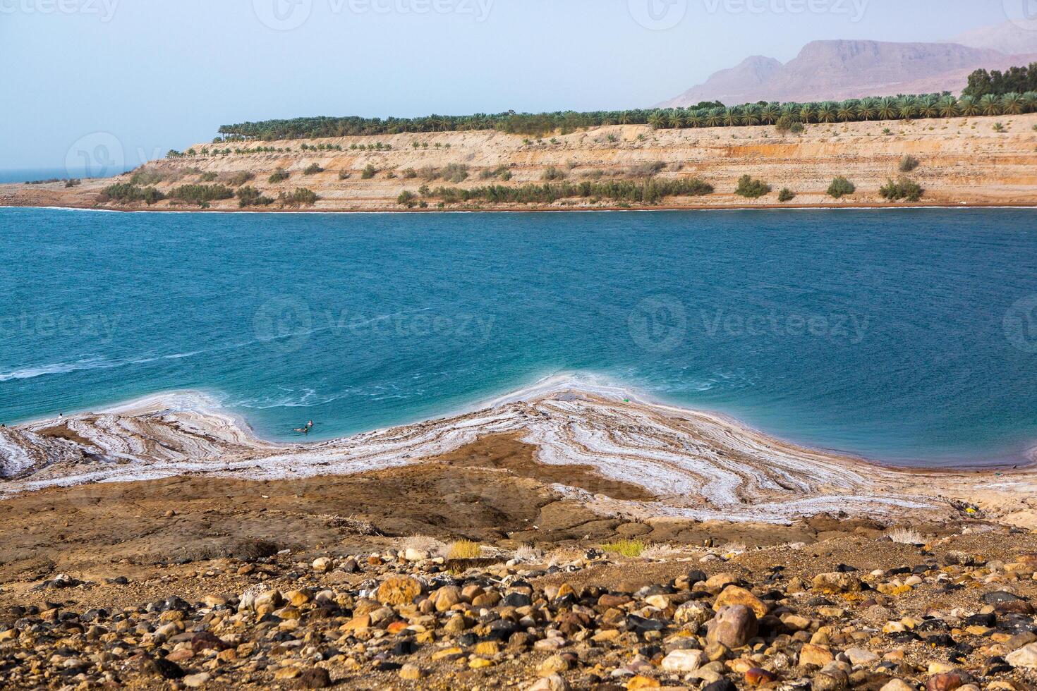 View of Dead Sea coastline at sunset time in Jordan. Salt crystals at sunset. Dead sea landscape with mineral structures. photo