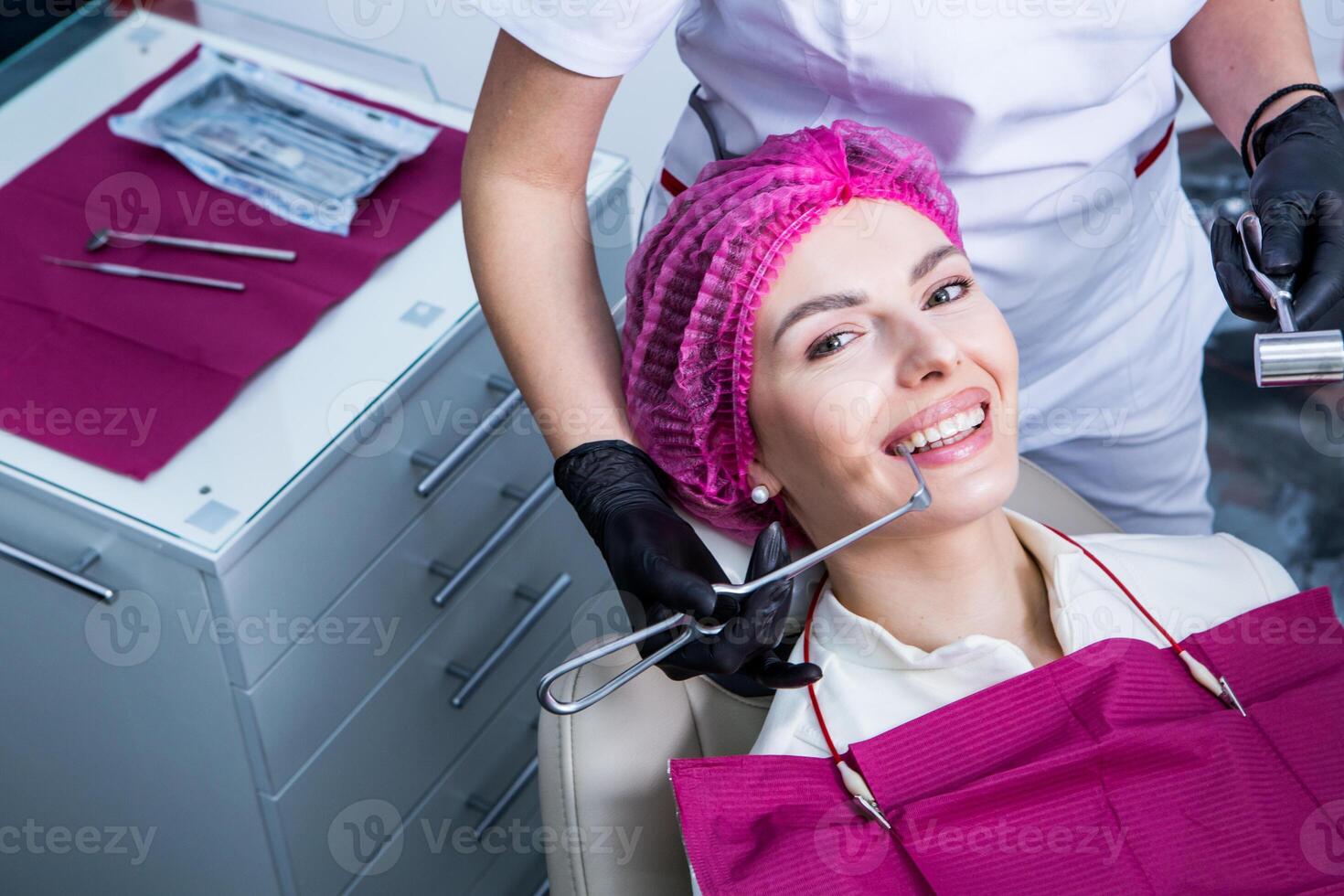 Dentist examining teeth of a young woman patient in a dental clinic. Dentistry concept. Dentist and patient in the dental office. photo