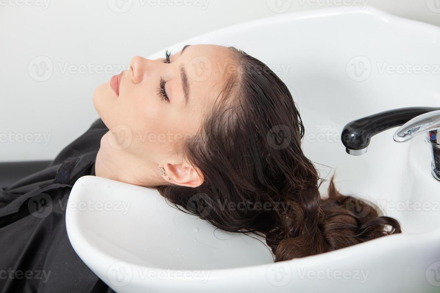 Portrait of a beautiful woman with long brown straight hair in a beauty salon. photo