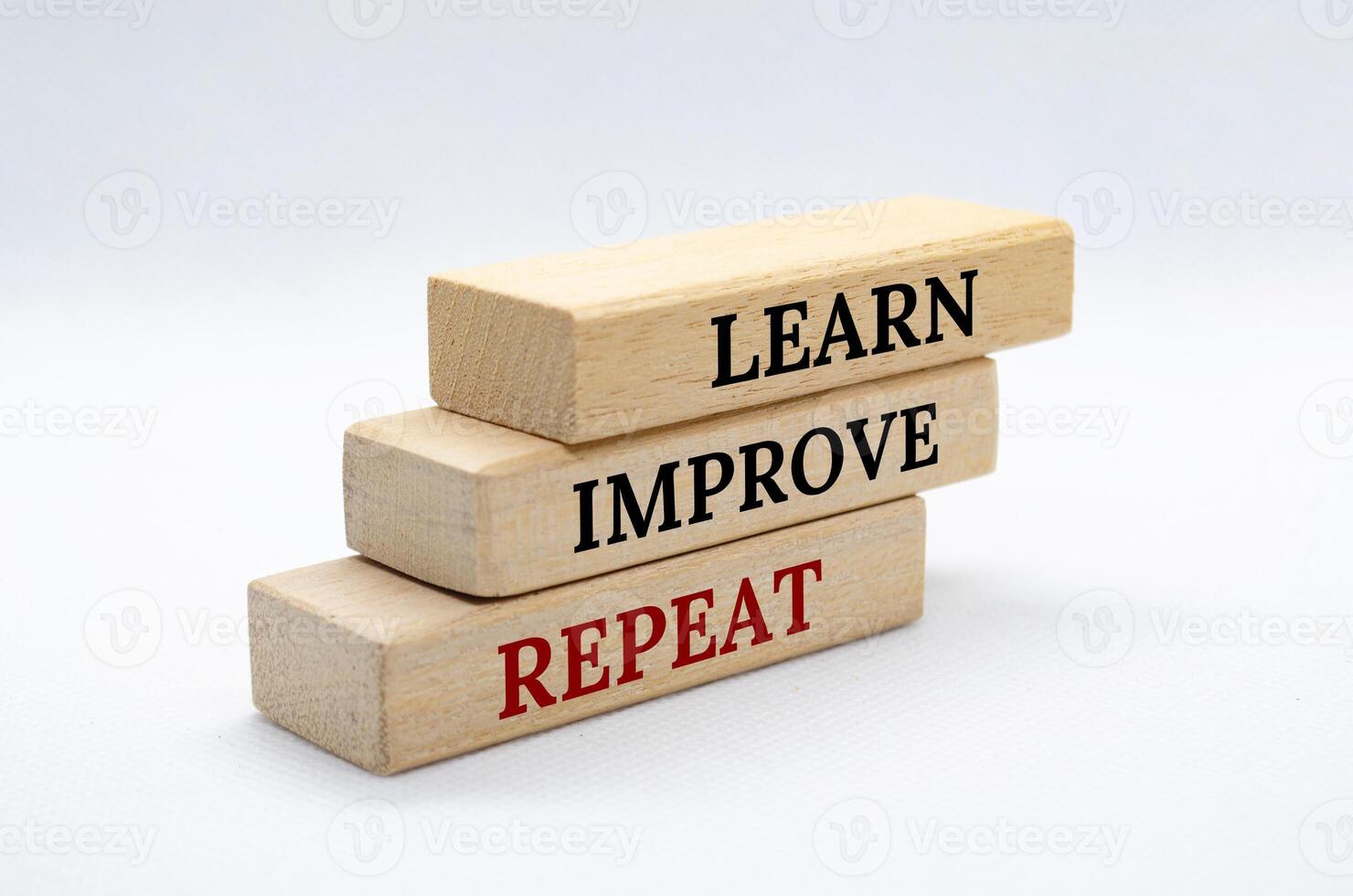 Learn, improve and repeat text on wooden blocks with white cover background. Improvement concept photo