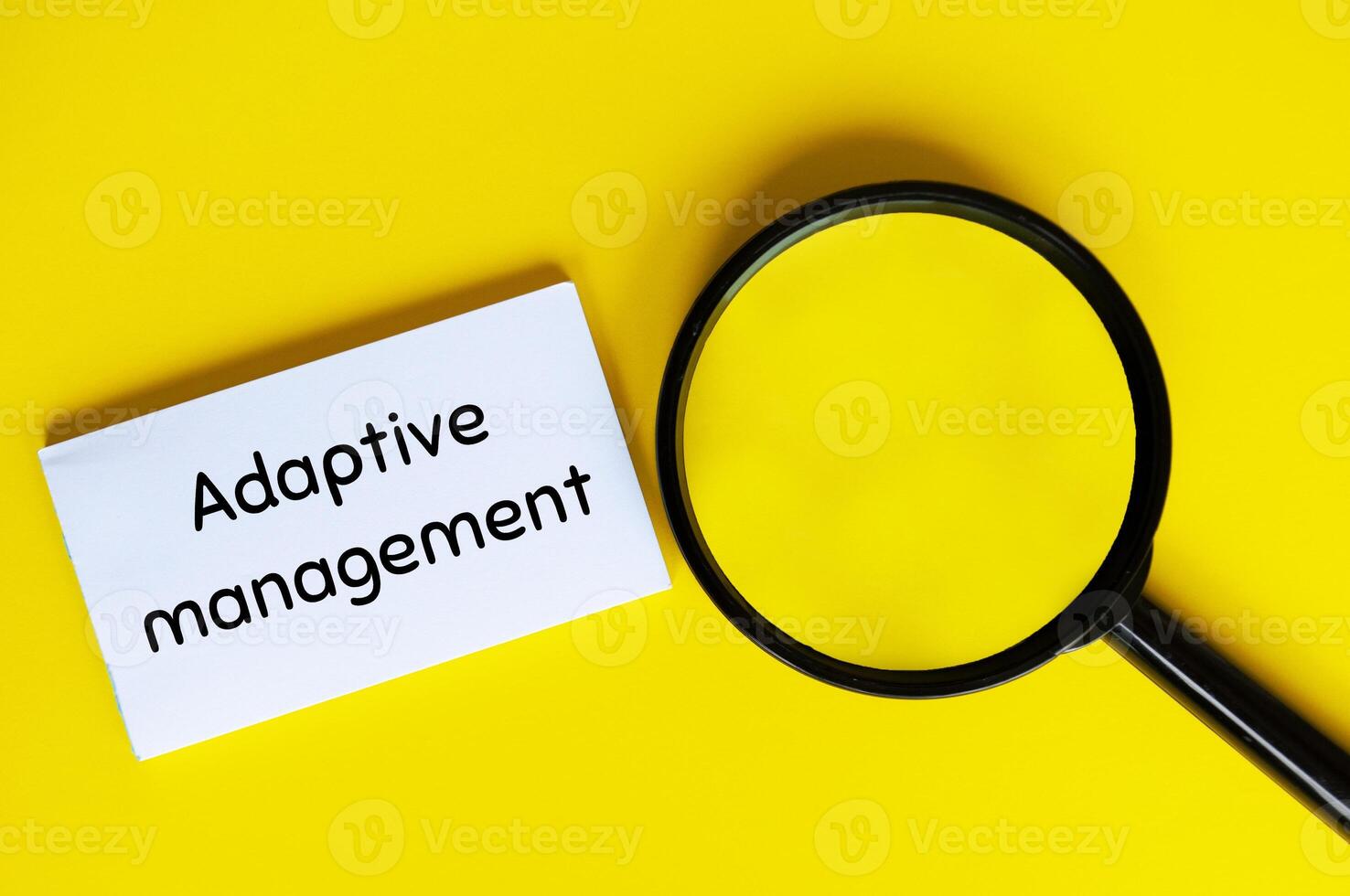 Adaptive management text on white notepad with magnifying glass. Business adaptivity concept photo