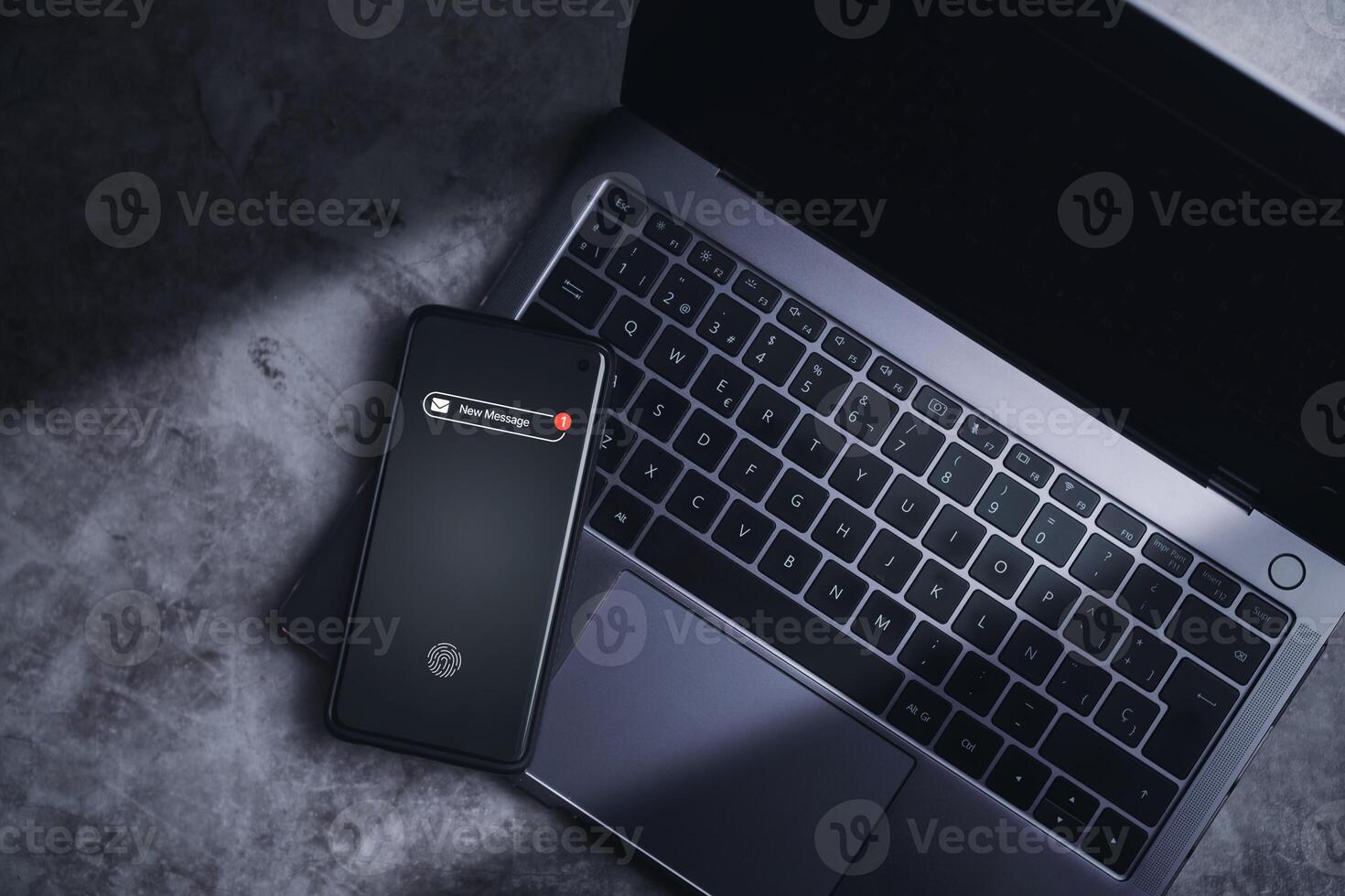 Smartphone resting on laptop with a new message notification on screen. Communication business technology. Inbox view. New e-mail on mobile smartphone. photo