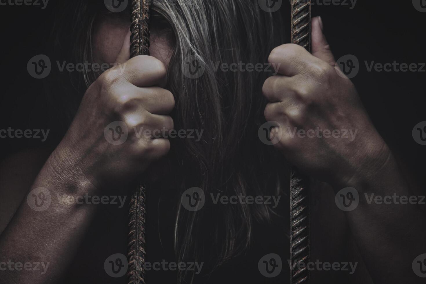 sad young girl holding a steel cage in old iron bar. children prison and prisoner concept photo