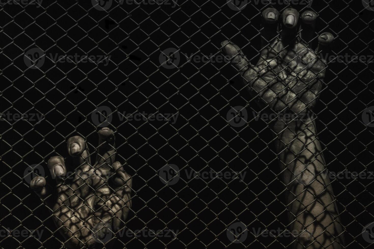 closeup of hand in jail, hands on a black background, a prisoner behind bars, trapped photo