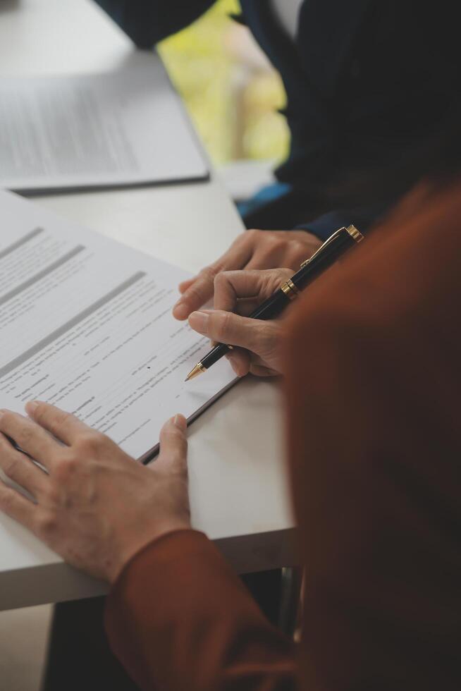Lawyer, legal advisor, businessman brainstorming information on agreement details Business contracts in legal processing books for accuracy in contract documents. joint financial investment. photo