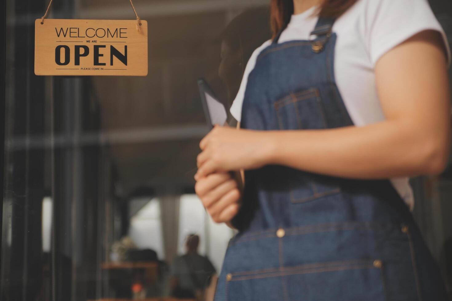 Startup successful small business owner sme beauty girl stand with tablet smartphone in coffee shop restaurant. Portrait of asian tan woman barista cafe owner. SME entrepreneur seller business concept photo