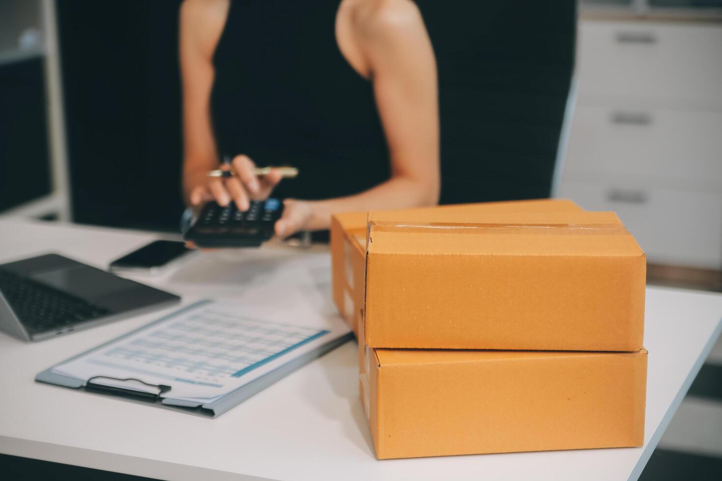 businesswoman start small business and successful SME entrepreneurs asian woman hoding boxs works from home delivering parcels online. SME delivery concept and packaging photo