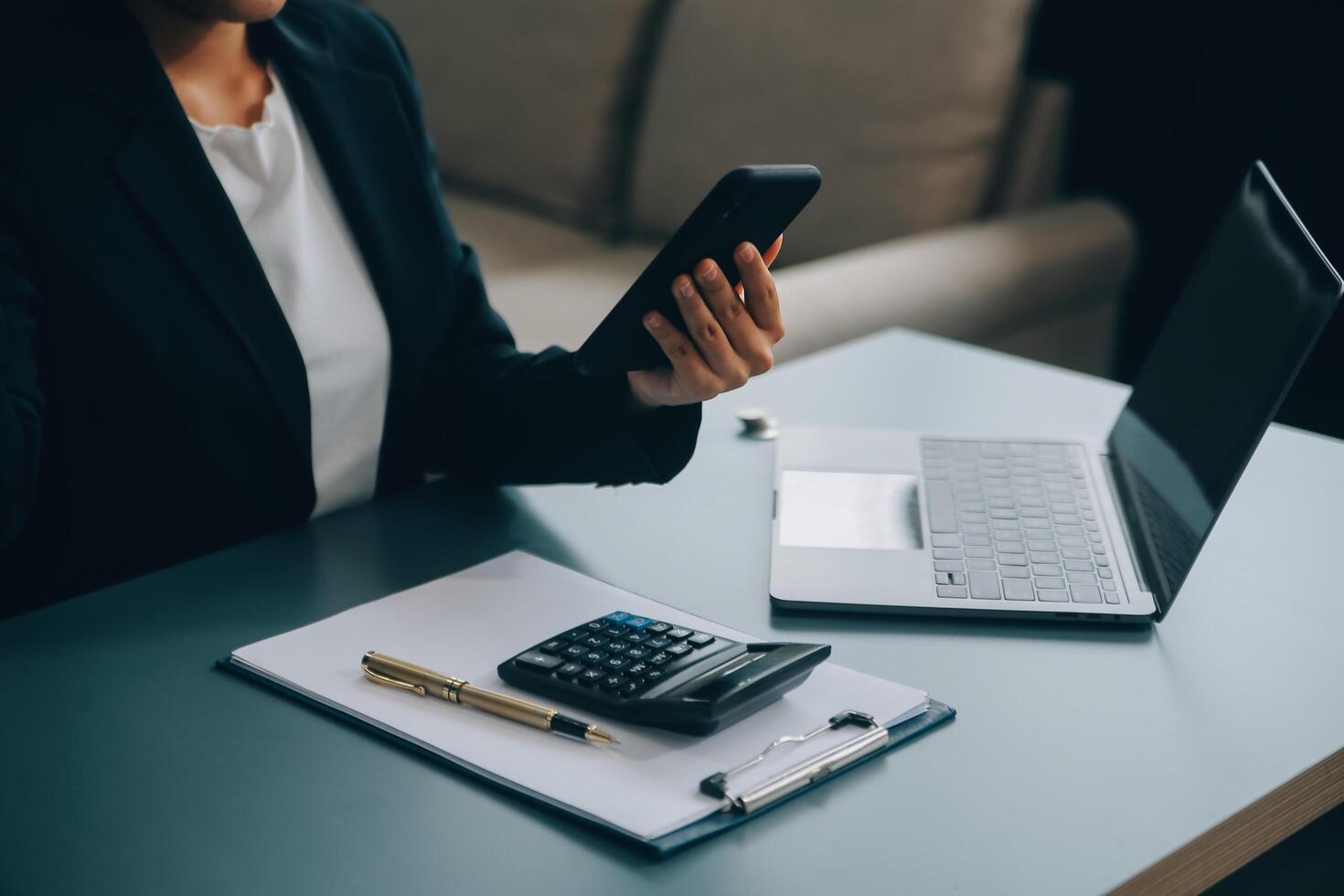 Hispanic businesswoman in formal attire in her office happy and cheerful while using smartphones and working. Young businesswoman using apps on cell phones, reading news, fast connection photo