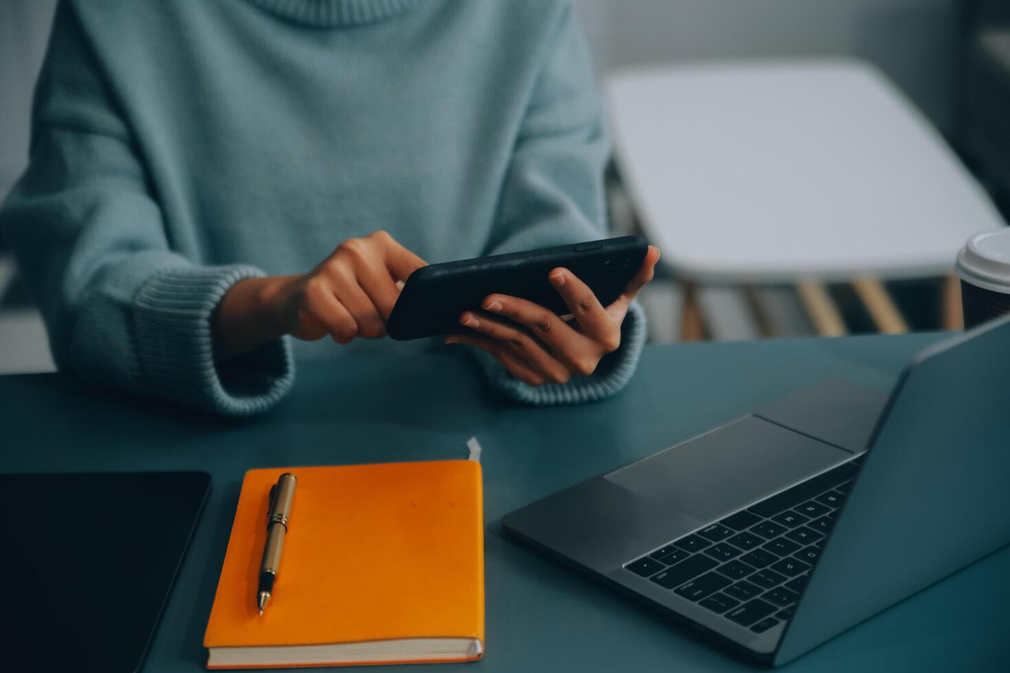 Happy pretty millennial Indian girl relaxing at home, resting in armchair, typing on smartphone, using online app, software, shopping on Internet, making video call. Mobile phone communication photo
