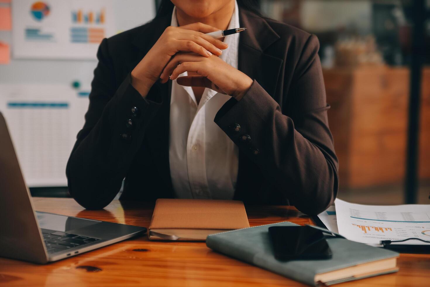 Asian businesswoman in formal suit in office happy and cheerful during using smartphone and working photo