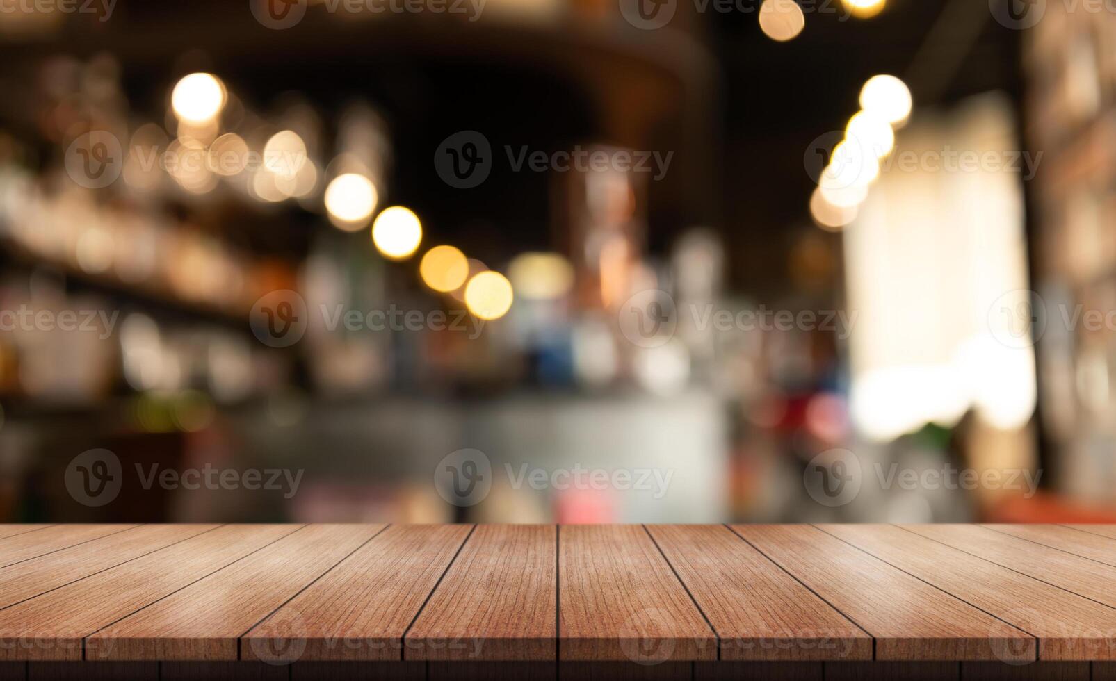 Empty wooden table top with lights bokeh on blur restaurant background. photo