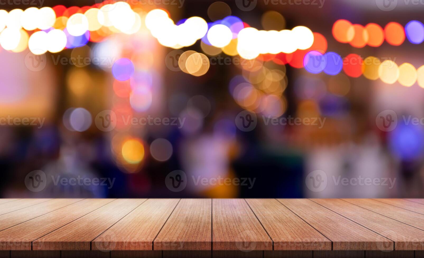 Empty wooden table top with lights bokeh on blur restaurant background. photo