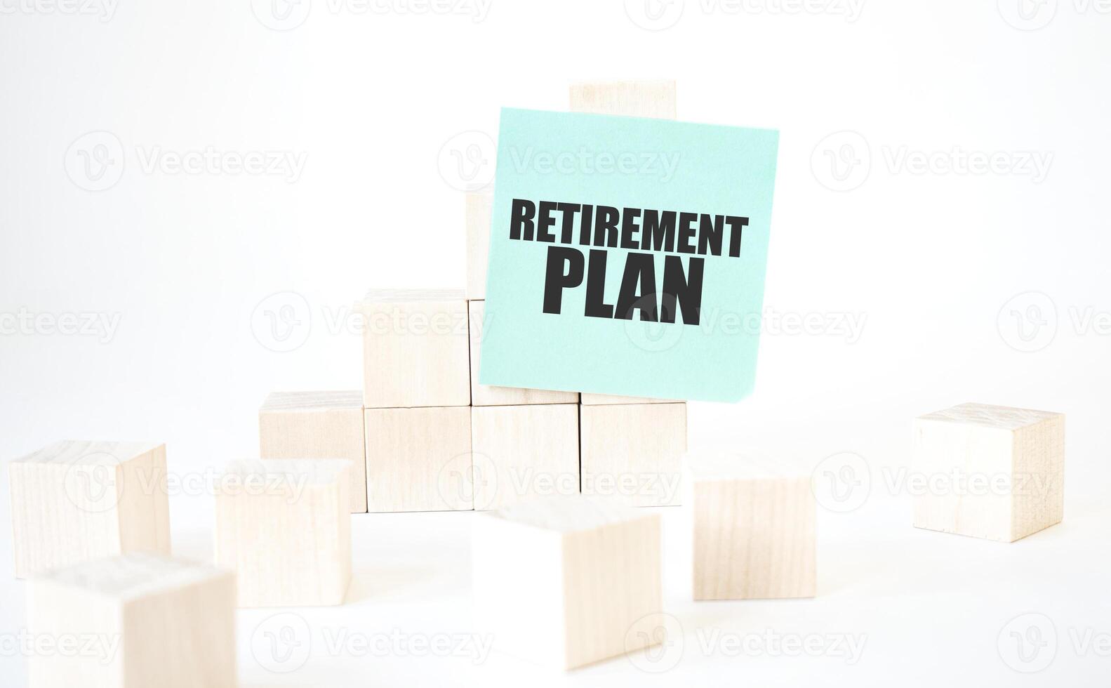 Text RETIREMENT PLAN writing in green card cube ladder. White background. Business concept photo
