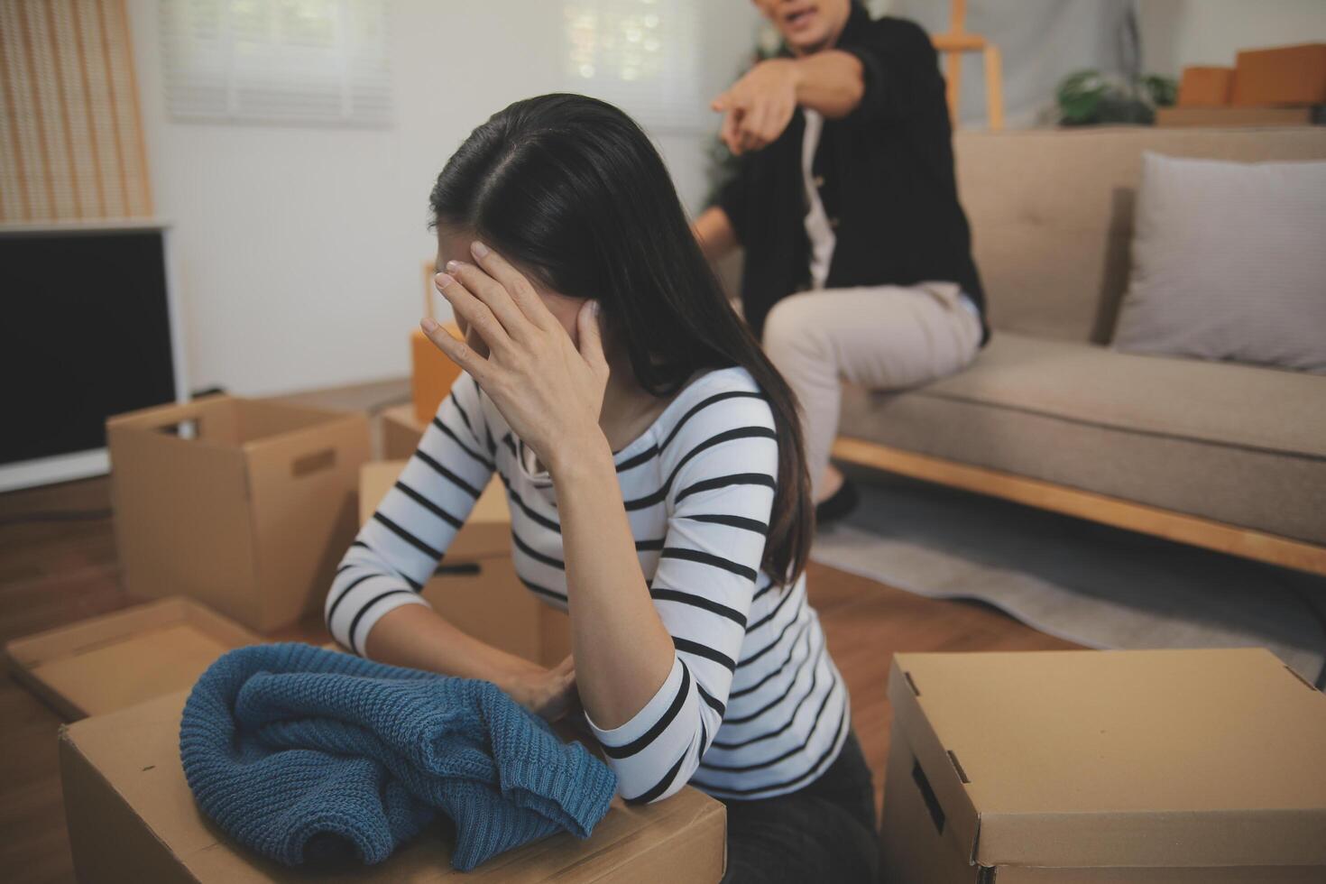 Two Asian blogger showing clothes in front of the camera to recording vlog video live streaming at her shop. Online Shopping Cart notion. on sofa at home photo