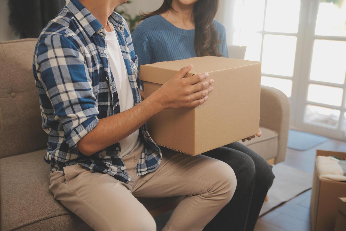 Two Asian blogger showing clothes in front of the camera to recording vlog video live streaming at her shop. Online Shopping Cart notion. on sofa at home photo