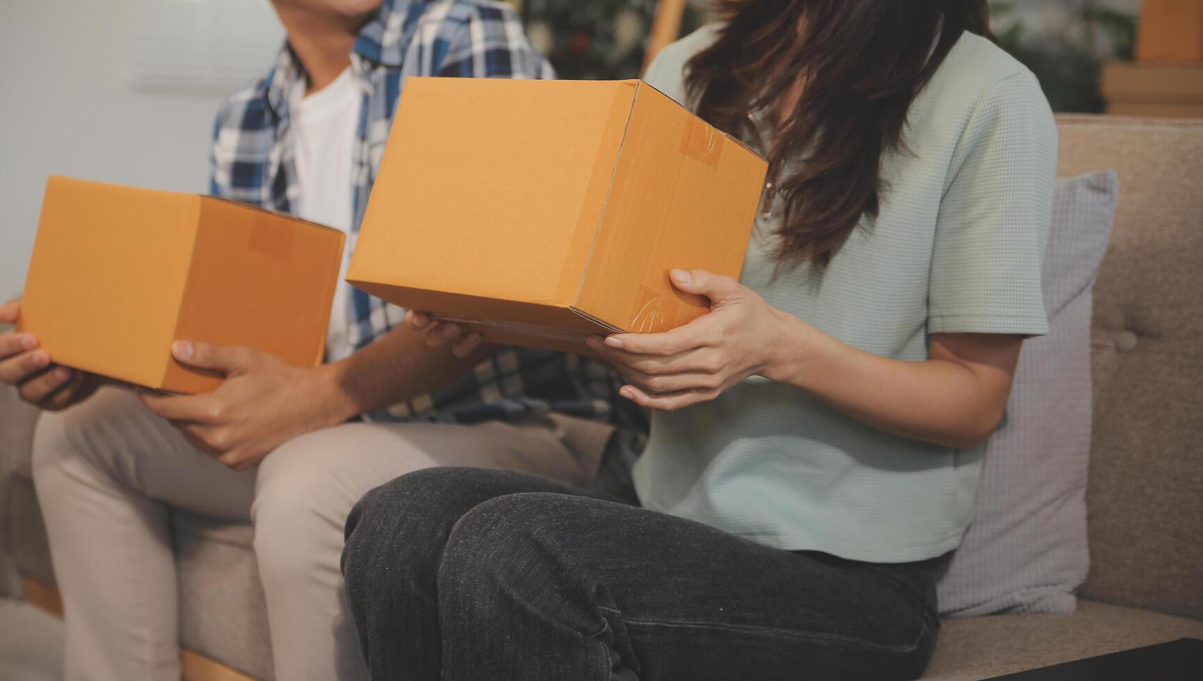 Two Asian blogger showing clothes in front of the camera to recording vlog video live streaming at her shop. Online Shopping Cart notion. on sofa at home photo